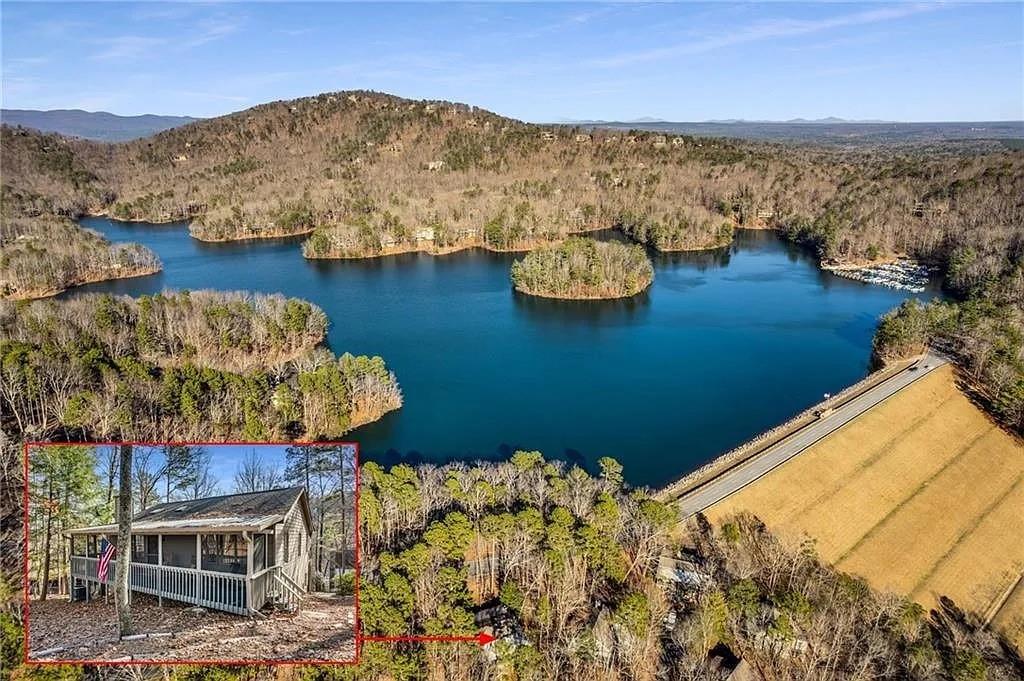 Your mountain escape awaits! This beautifully renovated 4-bedroom, 3-bath cabin in Big Canoe offers a serene lake view and is just steps from Lake Petit and Big Canoe’s top amenities. Sold fully furnished and vacation/rental-ready, it’s the perfect blend of charm, comfort, and convenience.
Thoughtfully updated with a new roof in 2025 as well as newer HVAC, hot water heater, attic insulation, and smart dryer in 2023/2024. The main level features a rare layout with two bedrooms—including a spacious primary suite with walk-in closet and full bath. The open-concept kitchen shines with granite countertops and stainless steel appliances, with two refrigerators and two microwaves, flowing into a warm great room with hardwood floors and a cozy stone fireplace. Downstairs, the terrace level offers two additional bedrooms, a full bath, den, game room with pool table, and kitchenette—ideal for guests or rental use. With a solid rental history, this home is a great income-producing property as well as a private getaway.
Enjoy peaceful mornings on the screened-in front porch overlooking Lake Petit, where tranquil views set the tone for a relaxing day. In the evenings, unwind on the screened-in back porch, accessible from both the kitchen and the primary suite—perfect for dining al fresco or enjoying the mountain air. Big Canoe’s resort-style amenities await—including a marina, beach club, fitness center, golf course, and miles of scenic hiking trails—just an hour north of Atlanta. Whether you're fishing on the lake or exploring the community’s natural beauty, this home, with its modern updates, offers easy access to everything that makes mountain living special. Buyer to verify all information and dimensions deemed important.
