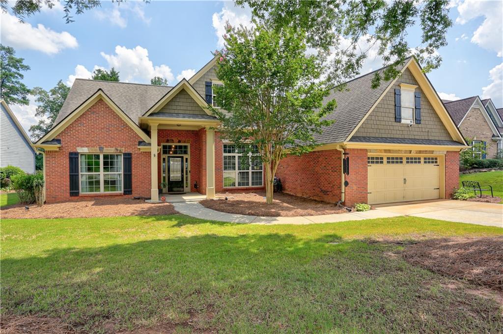 Welcome to this unbelievably spacious and updated ranch style home exuding charm and character. On arrival you are met with professional landscaping and a sophisticated facade punctuated by grand columns. Upon entry you are greeted by gleaming wood floors that extend throughout this carpet-free home. The open floor plan harmonizes modern design and classic details. Flanking the foyer is a large, versatile den or home office. Modern fixtures and soaring ceilings adorn the delightful formal dining area that adjoins the living area with double-sided fireplace. Entertaining and everyday meal preparations are made easy in the well-appointed kitchen with SS appliances and an abundance of beautiful cabinetry. The window lined breakfast nook and sunroom lend a picturesque view of the back yard. Split bedroom plan with two generously sized secondary bedrooms and a full bath on one side of the home, in addition to a half bath for guests. Prepare to be amazed by the enormous primary retreat with a dazzling spa like bathroom. Upstairs is a fourth bedroom and an updated full bathroom creating a functional space with endless possibilities. Step outside to discover a covered patio highlighting the wonderful backyard with new fence. Conveniently located near shopping, restaurants, Mall of Georgia, Hamilton Mill and both 85 and 316.