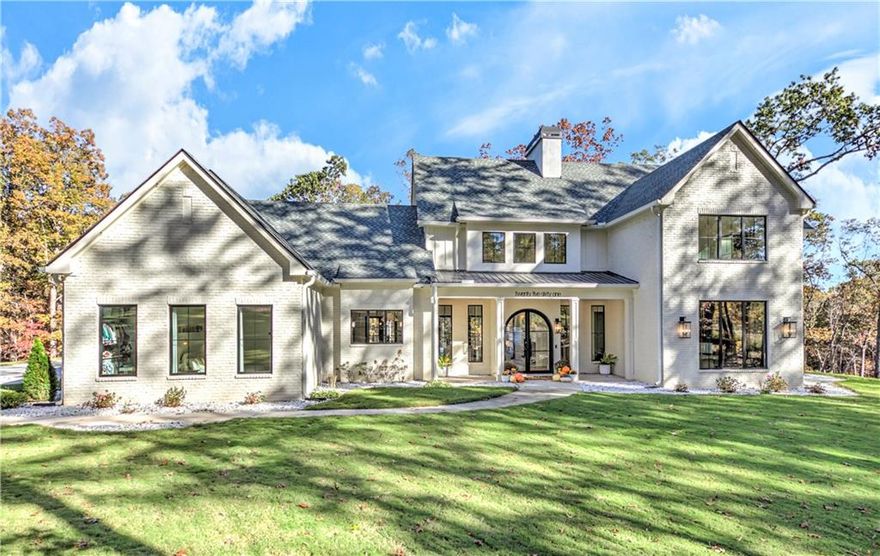 Welcome to this stunning, custom-built Modern Home, completed in Spring 2025, and perfectly nestled on a private, wooded 2.11-acre lot.
Every inch of this residence showcases exceptional craftsmanship, thoughtful design, and high-end finishes throughout.

Step inside to find soaring cathedral ceilings, custom-tinted Pella windows (main house & carriage house) , and an oversized double arched iron front door framed by 19th-century stone accents. The open-concept great room flows seamlessly into the dining area and chef’s kitchen — ideal for entertaining.

Property Features

6 Bedrooms | 5.5 Baths | just over 5,200 Sq Ft.

For those auto enthusiasts this home features a

5-Car Garage (each with Wi-Fi–controlled openers, 8-ft custom doors, and 220V EV outlets for convenient auto charging).

Separate Guest Quarters / Carriage House complete with full kitchen, living area, and private suite. Future expansion available upstairs (already framed and spray foam insulated). 

Three Primary Suites on Main – Master suite and secondary master suite on the main level of the main house. Master suite on the main level in the carriage house.

3 Spacious Bedrooms Upstairs with dual-vanity bath. 

Bonus/Theater/Media Room with full bath, painted in designer Iron Ore tone & tucked privately away upstairs. Could be used as a flex space for an additional 7th bedroom suite. 

Interior Highlights

Designer wood-beam ceilings in both main-level suites.

Gorgeous Private Office space conveniently located off the main living room. 

14-ft accordion custom glass doors opening to the rear patio and pool area. 

Chef’s kitchen with oversized island, high-end appliances, under-counter wine cooler, panel-matched dishwasher, and a mix of antique bronze and polished nickel hardware.

Butler’s pantry with built-in beverage fridge and full custom cabinetry.

Fully built-out walk-in pantry and laundry room with built-ins and folding station.

Master bath with expansive tile shower, dual vanities, his-and-hers closets, and direct laundry access.

Every bathroom features custom tilework and glass shower doors.

8-ft doors throughout main levels of both homes.

Exterior & Systems feature 

Brick, Stucco, and Board & Batten exterior with LED soffit lighting front and back.

Complete spray foam insulation and dual upgraded Trane HVAC systems with 4 Wi-Fi–zoned thermostats make this home super energy efficient. 

Complete water filtration system servicing both homes.

Saltwater pool with turf surround, Jandy programmable pump system, LED lighting, and in-ground drainage.

Outdoor living: patio plumbed for propane kitchen, fenced turf area, 4 custom garden boxes, and play area featuring wood/pea gravel staircase, swing set, and in-ground trampoline.

Extensive sod and landscaping with 8-zone Rainbird Wi-Fi irrigation system.

Large driveway and extra-wide turnaround space.

Located in the highly sought-after Creekview High, Creekland Middle, and Macedonia Elementary school districts.

This extraordinary property offers a perfect balance of luxury, privacy, and functionality — a truly one-of-a-kind home built to the highest standards.