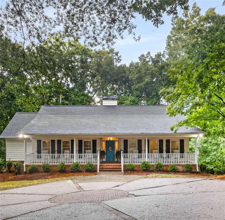 Welcome to this stunning 4-bedroom, 3-bath Ranch home on a beautifully finished terrace level that offers the perfect blend of southern charm and modern comfort with seasonal lake views and lake access! The inviting covered front porch, complete with rocking chairs, extends the full length of the home and sets the tone for relaxed living, just add a glass of sweet tea and enjoy these evening summer storms. Inside, the bright white kitchen features granite countertops and an abundance of cupboard space and natural light from windows throughout the home. The spacious vaulted family room, accented with wood beams, flows seamlessly with real hardwoods throughout the top floor. The spacious primary suite is conveniently located on the main level with a shiplap, updated primary bathroom and an amazing walk-in closet.
Just follow the path down to the lake with your kayaks that can be stored under the covered patio off the terrace level. Downstairs you'll also find 10 ft ceilings, a large spacious family room, 2 bedrooms and a full bath which can be great for family visitors. Bonuses include the expansive Trex deck off the kitchen which is perfect for outdoor gatherings, while the side-entry garage and large front parking pad offer plenty of parking options. This home has over $43K in updates and combines character, space, and functionality in a prime setting. Don’t miss your chance to make it yours!