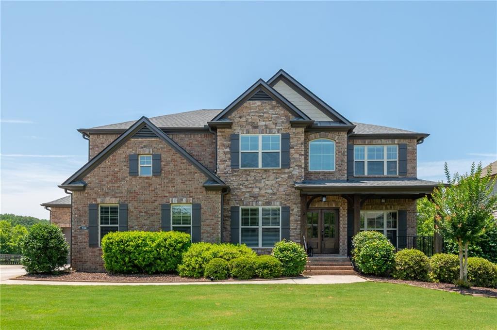 Immaculate Luxury Home in the sought-after Swim and Tennis Community of Estates at Hickory Flat. As you enter the home, the Main Living Area is filled with tons of light, beautiful hardwood floors and an Open Floor Plan that is perfect for entertaining. The Dining Room, on you right when you enter, is perfect for the largest of gatherings and on you left is an Office or Playroom. The fully renovated Gourmet Kitchen, that is the heart of the home, overlooks the Fireside Family Room. Kitchen features a large island, breakfast bar, quartz counters, gas cooktop, double ovens, marble backsplash, a full suite of Stainless Steel appliances and a Walk-in Pantry. The Bedroom with En-Suite Bathroom on the Main Floor is perfect for guests, while you can escape upstairs to your Spacious Owners Retreat complete with trey ceilings, hardwood floors and huge walk-in closet. The Owner's Bathroom is equally stunning with dual vanities, tile floors, glassed-in shower and soaking tub. There is a Bonus / Family Room on Upper Level that is great for watching movies, reading or just hanging out. Three generously-sized secondary bedrooms, two full baths and Laundry Room complete the Upper Floor. Enjoy the recently Fully Finished Daylight Basement with walk-out access to the patio and level yard! Basement features Living Area with Fireplace, Built-In Bar with Wine Cooler and Refrigerator, Theater Room, Exercise Room / Bedroom and Full Bath. For outdoor entertaining, you'll delight in the expanded covered back porch and pergola-shaded grill deck, as well as the beautiful stone-paved patio with built-in fire pit that overlooks the private fenced backyard. Brand New Roof installed in 2024! Community Amenities include Clubhouse, Swimming Pool, Tennis Courts and Playground.