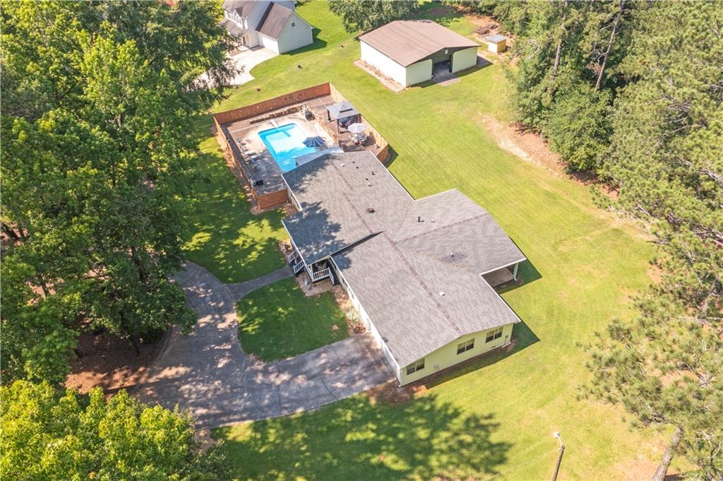 Beautiful, well maintained, 4 BR home, sitting on 2.4 acres in the prestigious Norris Lake community. Private fenced pool, huge 1600 square foot storage building with 40 X 8 parking pad. A beautiful level lot with trees galore. If you are looking for a home that is located in the suburbs but convenient to shopping, entertainment and the Big-City, (Atlanta, GA) then search no further. Norris Lake is not just another private community with a pool; the amenities include a 106.7 acre lake (great for fishing, boating, sailing, and jet-skiing!), a sandy beach, shaded beach with picnic area, parks, tennis courts, community garden, and a Junior Olympic-sized pool. One of a few lakes in the area, that allows motorized boats. New owner will have to apply for membership. Private pool @ the subject property has a multi-level patio, a professionally constructed stationary gazebo & a covered deck. Property has a 600' deep well with filtered water. A circular driveway, multiple parking spaces, & all the other facilities have allowed the owners to host special events & large family gatherings. This home & large lot have many outstanding features with a quite country atmosphere. Thanks for showing, bring your best offer.