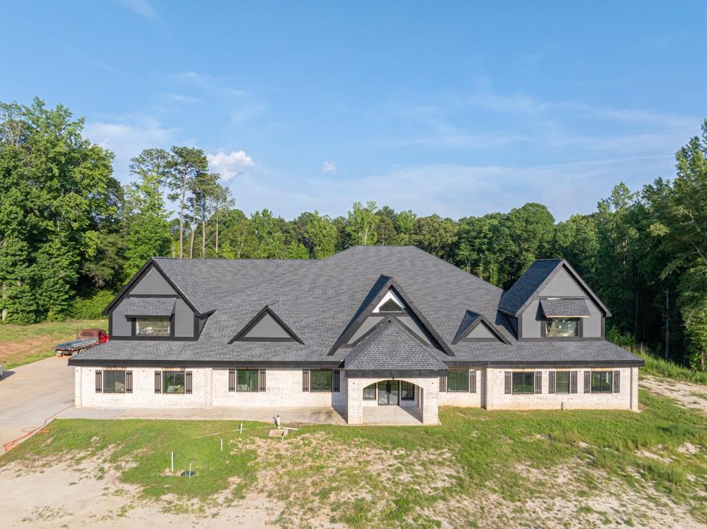 Magnificent, Amazing, Quality... These are just a few of the words used to describe this New Construction home located in Loganville, GA. Boasting 9 bedrooms, 7 full bathrooms, and 3 powder rooms. All bedrooms, including the Primary suite, are located on the main floor along with a formal living room, family room, Dining room fit for 20, Craft room, Office, Personal Gym prewired for a Sauna, Oversized laundry equipped with 3 laundry hooks ups plus a dog washing station. The oversized kitchen is set for a large island, two ovens, oversized stove, 2 built-in microwaves, pre plumbed coffee nook, spaced for Subzero Refrigerator. Butler's pantry leads into a truly oversized pantry wired for 2 additional freezers. My personal favorite part of the home is the Primary Suite. Floor-to-ceiling fireplace, Walk-in shower for 2 (really could fit way more!) Overhead Rain waterfall with two shower hooks ups, Step up Jacuzzi tub with waterfall accent wall, 3 vanities, and a TWO STORY Closet!!! Space GALORE! There are truly far too many details to list but this home is well thought out and is a must-see. The Seller has dedicated one room as headquarters to go and adjust all the functionality of the home. Also, there is another room dedicated to all the drawings/ engineering of the home so if there is ever a malfunction it can easily be located. There is another room which is also a favorite of mine, and that is the Decorations room!! You can easily move all of your holiday decor to one room, shut the door, and be ready for the next season. The house has been fitted for 5 HVAC units, 2 Water heaters, and has 2 septic systems installed. Upstairs is truly an entertainer's dream equipped with a room for Video Gaming, A full game room space, A cathedral-style theater, and a full Kitchenette. Also upstairs is another flex room or could be a 10th bedroom, full bath, and powder room. Are you a Car Enthusiast? Great because we have you covered with an 8-car garage prewired with an electric charging station for your car and your motorcycles! Outside of the home as you wander almost 11 acres you will find a 3200-square-foot shop fully run with power, water, and a powder room. Several fenced-in areas to home all your furry friends! Pastures, chicken coops, and pig pens on site! And we can't forget about the custom-built dog palace alongside the fenced-in pasture! Please check out the Virtual Tour attached to get a better idea of truly how amazing this home and property are! Sales price has increased due to completion of insulation and Sheetrock in the home. Next week seller will order tile and flooring for bathrooms as well. Seller would prefer to sell unfinished however can negotiate with buyer to complete home. Price is subject to change as seller is continuously working on property and home. There is still time to customize this home to your taste, so act fast to finish out your dream home.