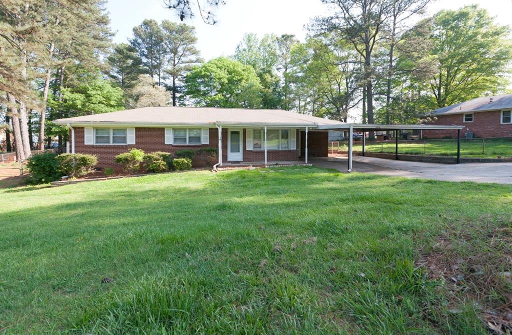 Welcome to this beautifully maintained 4-sided brick ranch offering classic charm and modern convenience. Located in a quiet, friendly neighborhood just minutes from various schools, popular shopping spots, and major highways for easy commuting. Interior Highlights: Gorgeous hardwood floors throughout + Spacious and open kitchen with generous cabinetry and prep space + Convenient utility room featuring washer/dryer, water heater, shelving, workbench, and adjoining mud room + Expansive living room perfect for relaxing or entertaining + 1.5 well-appointed bathrooms. Outdoor Features: Fully fenced backyard with level grassy area -- ideal for pets, play, or gardening + Large outbuilding/storage shed big enough for a small boat or serious tools + Inviting covered front porch and carport for sheltered parking + Long driveway offering ample additional parking. Additional Perks: Easy upkeep with durable construction + Security System In Place + Recently updated mechanical systems for peace of mind + Comfortable, affordable, and move-in ready.