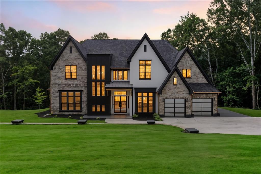 Step into a world where innovation, craftsmanship, and contemporary luxury blend seamlessly to create a home like no other. Nestled behind a private gated entrance situated on a large private lot, this custom-built estate embodies timeless sophistication with modern conveniences designed for effortless living and elegant entertaining.
The home commands attention with its rounded matte black and copper gutters, Wi-Fi-enabled LiftMaster gates, and a striking matte black post-capped fence constructed from massive 6x6 railings and bold 8x8 posts—framing the residence in refined strength. The exterior showcases ceramic-coated paint that’s not only beautifully smooth but also self-cleaning for enduring beauty with minimal maintenance.
Step inside through 8-foot sun-repellent green-tinted windows framed in sleek black vinyl, and be welcomed by soaring ceilings, 12-inch baseboards, and 8-inch casings that echo the home’s meticulous detailing. A dramatic 25-foot foyer chandelier sets the tone for what lies ahead.
The heart of the home is a designer chef’s kitchen, curated for both performance and style. It features granite countertops, a commercial-grade JennAir appliance package with double ovens, a professional cooktop with an infused griddle, a custom 7-foot panel-matching refrigerator, a drawer microwave, and an artistic charcoal-finished vent hood. A fully equipped butler’s pantry with wine fridge and built-in cabinetry leads to a walk-in chef’s pantry complete with glass door, custom shelving, and cabinetry for large appliances. Formal dining room with coffered ceiling, a 6-foot chandelier, and gallery-style wall inserts
Every inch of the home is integrated with smart living features—including Wi-Fi-enabled smoke detectors, smart switches, facial recognition exterior locks, and Wi-Fi lights with built-in speakers in every room for a fully immersive audio-visual experience. The entire home is pre-wired for surround sound, including a media room with motion and sound-censored LED lighting for an unforgettable movie night.
The primary suite on the main level is a sanctuary with 16-foot vaulted ceilings, a custom recessed niche with ambient lighting, and a spectacular walk-in closet featuring motion-activated lighting, custom built-ins, and a full-length dressing mirror. The spa-inspired ensuite is a masterpiece: marble-clad walls, a standalone soaking tub, oversized vanities with dedicated makeup station, a walk-in glass shower, and a digital bidet offering heated/cooled water and a remote control.
Elegant living room with 16-foot coffered ceilings, gas fireplace with custom stucco mantle, and black built-ins with floating shelves. Bright and airy with triple transom windows and an 8-foot iron glass door.
The upper level offers a flex room/rec space, a private home theater with LED and sound-responsive lighting, and three beautifully appointed bedrooms. One suite features floor-to-ceiling honeycomb and dymo wavy tiles, a matte black mirror, and double vanity with Corian counters. Each bedroom includes custom California-style closets for optimal storage and design.
Venture out back to a resort-style covered porch, designed for grand entertaining or serene evenings. Tongue-and-groove wood ceilings soaring over 16 feet, brick-accent columns, slate flooring, and motion-activated linear soffit lighting. The outdoor kitchen is finished in matte black leathered granite and equipped with Lion appliances—including a built-in fridge, grill, and sink—while a gas log fireplace with a 15-inch cedar hearth completes the ambiance.
Additional features: NO HOA
-Three-car tandem garage with additional RV/boat parking pad
-8-foot matte black, full-view metal garage doors
-Glass staircase railing with matte black accents overlooking the open loft and foyer
-400-amp service pre-wired for a future pool
-Dedicated office space with serene backyard views—perfect for working from home