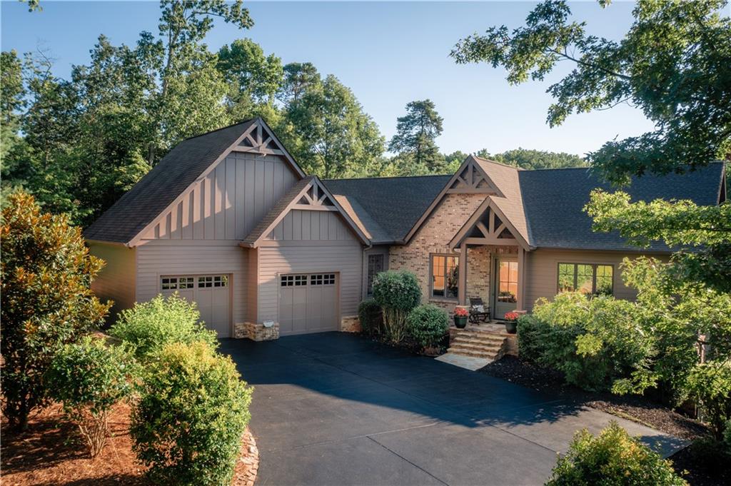 Built by a well-known Big Canoe custom builder and featured in 2018 Big Canoe Tour of Homes, this modern artistic craftsman home features one of the very few Saltwater Heated Indoor Pools in Big Canoe! Hike-Out your front door with a 1-2 min walk to the Wildcat Red & Blue Loop paved trail intersection, dog park and outdoor fitness area along miles of paved Wildcat paths connecting to a variety of Big Canoe hiking trails. Proximal to the front gate and Wildcat pool, this home was intelligently designed to awaken natural light at every turn for both comfort and elegance. A spectacular cathedral ceiling entrance, accented by solid wood exposed beams, invites you to explore the open-concept main living level perfect for entertaining. The sun-filled family gathering room featuring a stunning floor to ceiling gas fireplace is a cozy setting for friends and family during every season. A European concept dine-in kitchen with Restoration Hardware lighting and unique sous chef hidden Butler’s prep and presentation pantry flow with leading lines to the mountain views. Adjust the 6600-gallon indoor endless pool to your fitness level preference aside a cozy fireplace for ambiance—swim or enjoy water therapy year round with EZ-Breeze windows open or closed. As a primary or secondary home, the pool is easy to maintain for homeowners who love to travel! The main-level primary suite features a spa-like master bath with Calacatta Italian Mint Marble, a luxurious tiled rain shower, and an oversized custom dressing area. A second master like suite on the terrace level provides added flexibility for short or long term guests. Premium features include PELLA WINDOWS & screens, 10'+ ceilings with 8’ solid doors on both main and terrace levels, oversized 2-car garage with upgraded epoxy flooring and EV Charging area, 7+ inch straight line solid baseboards & crown molding, mature landscaping designed by a master gardener with side tea garden, sun-filled gently sloped backyard with 6 bed planted vegetable garden, spray foam insulation for energy efficiency, 3 fireplaces, game room and outdoor billiards. GATED Big Canoe offers three lakes for boating, swimming and fishing with recent upgrades to the clubhouse about to reopen and marina area, golf, state-of-the-art fitness center with wellness spa, tennis, pickle-ball, abundant hiking trails, indoor and outdoor swimming pools, sauna and multiple inside the gates dining options. This nature community offers hundreds of clubs to be as social as you would like to be while adventure seekers find endless opportunities. Atlanta and Avalon-Alpharetta city options are still within reach! Buyer to verify all information and dimensions deemed important.