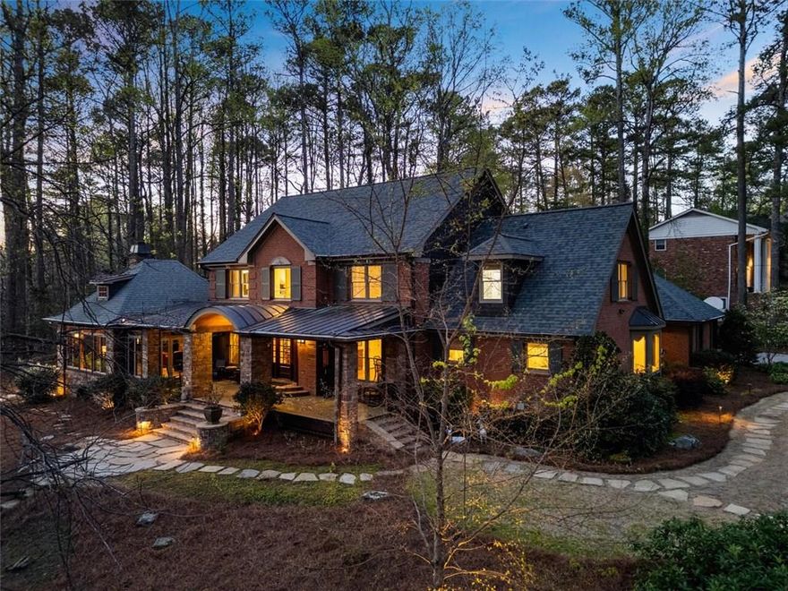 This one of a kind Dunwoody property is on the market for the first time in over 42 years. Lovingly expanded and renovated by the lifelong owners, it has been cared for and adored; and you will feel it from the moment you walk onto the exquisite front porch and through the front doors. Now with over 5200 square feet of above grade living space, 5445 Trowbridge sits on spectacular 1.2 acres with 4 designated outdoor seating areas, and view of a 3-acre lake (not on property). The home has dual master suites, including a 2020, $400k master on main addition with vaulted beamed ceiling, expansive windows overlooking the manicured rear courtyard and luxury master bath with step-less shower, separate vanities and huge closet with custom built-ins. Also on the main floor: graceful foyer open to living and dining room, butlers pantry with beverage fridge, office, large mudroom, and kitchen with breakfast room, walk in pantry and laundry. Kitchen has island, lovely quartz countertops, gas cooktop, copper sink and ample storage. The spectacular great room addition, affectionately "The Lodge" was designed intentionally to capture the unique features of the lot. This nearly 800 square foot room, walled by windows and centered around a wood burning fireplace is the heart of the home, built in 2010 for gathering family and friends. Upstairs find four more bedrooms: a second master suite featuring walk in closet and spa bath with dual vanities, separate soaking tub plus step-less shower; another ensuite bedroom with step-less shower; and two more large bedrooms that share a large hall bath with dual sinks and tub/shower combo. Downstairs find a basement with 463sf of finished space (plumbed should you chose to finish a bath) and another 1470sf of unfinished storage; all the basement square footage is moisture controlled so your belongings are protected. Hardwoods throughout the entire home; tile baths. Central vac, HVAC systems on seasonal maintenance contracts, termite bond, professionally landscaped. Recent upgrades and enhancements: tankless water heater, instant hot water and Flo by Moen system, updated electrical system, new garage floor, all new windows (2020), new driveway (2018), main house new HVAC (2020 and 2022), all bathrooms recently updated, copper gutters (2010), LeafFilter lifetime gutter guards (2011), extensive landscaping and landscape lighting and partially fenced. Beyond the home and property, experience the areas top public and private schools, easy access to GA400, 75/85 and 285, downtown Dunwoody, Avalon and beyond. Walk to Dunwoody Country Club or never leave the paradise of your own private retreat.