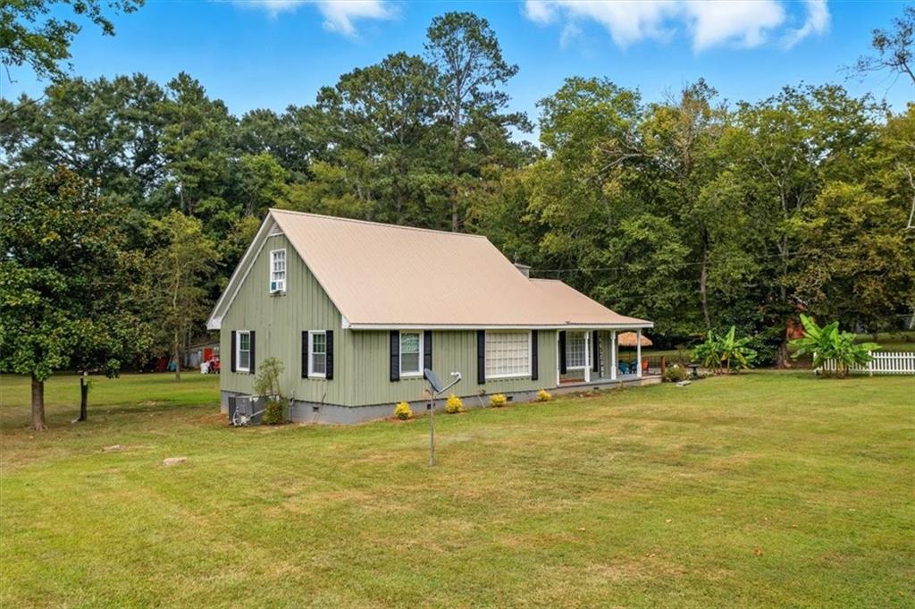 You have to check out this charming home right in the heart of Plainville! This gem offers plenty of room with four bedrooms, separate dining room, oversized laundry room, cozy foyer/den and eat-in kitchen! Gleaming hardwoods throughout! Rough sawn lumber siding and metal roof. Accessible ramps at front and back doors. Situated on a level 1+ acre lot with a 575 sf storage building and double carport! Set up your showing today!