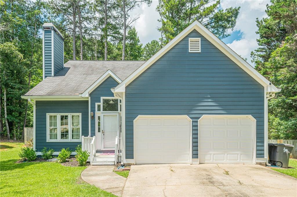 Blue siding exterior with white trim, featuring a two-car garage with white doors