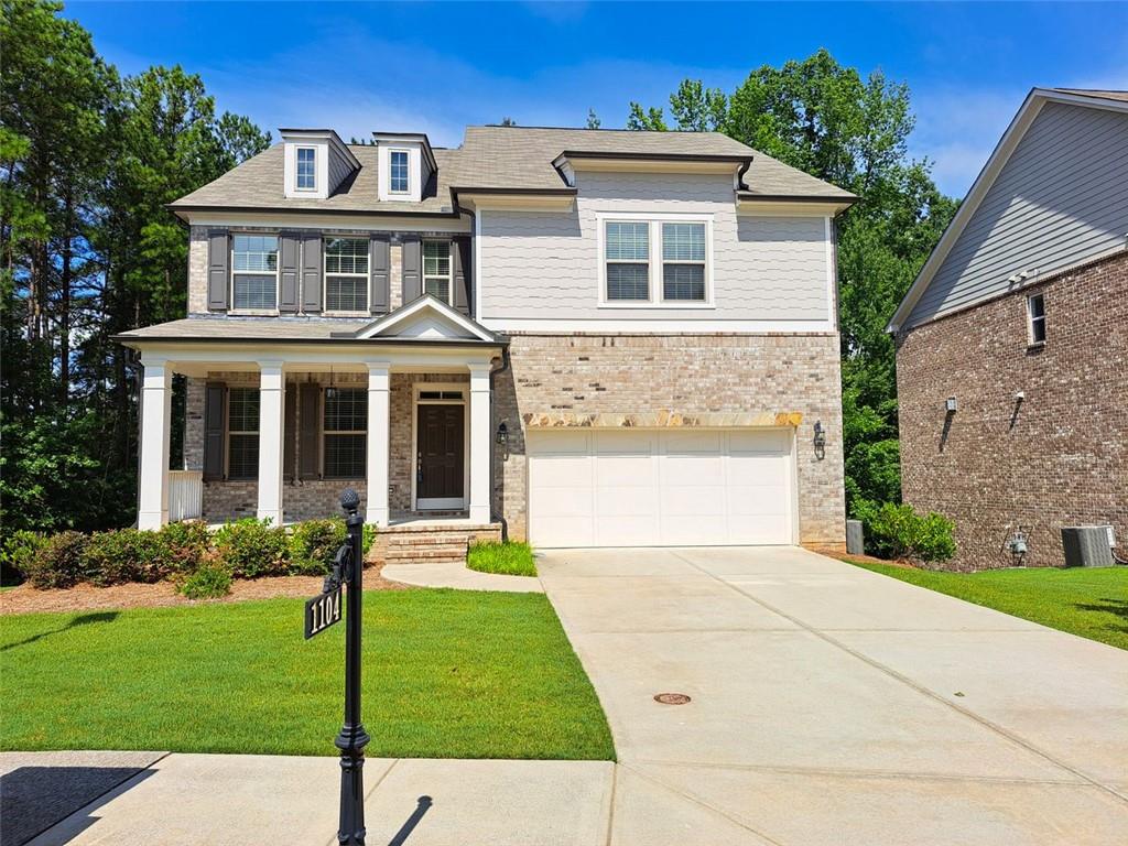 Move-in ready home in Kempston Place! Beautiful gated community located inside the emerging Technology Park, a thriving center for innovation, with easy access to work centers, recreation, dining, and shops in and around Johns Creek. This four-sided brick home on a wooded corner lot features an open concept floorplan, an unfinished basement, covered front porch with a sitting area, and a deck overlooking trees. Main level includes a welcoming foyer and separate dining room that leads into a gourmet kitchen featuring stainless steel appliances, stone counters, white cabinets, a large island, and a breakfast nook overlooking a large family room with a fireplace. The main level also has a secondary bedroom and a full bathroom. The upper level consists of two other secondary bedrooms, a shared full bathroom, a secondary suite (bedroom with full bathroom ensuite), a laundry room, and an oversized Primary Suite. The gorgeous Primary Suite boasts a luxurious ensuite bathroom with a separate tub and shower, double vanities, and a large walk-in closet. Spacious 2-car garage and lots of space for additional parking on the extended driveway. Everything you are looking for in the perfect home is all here at 1104 Hemingford Way, come see for yourself!