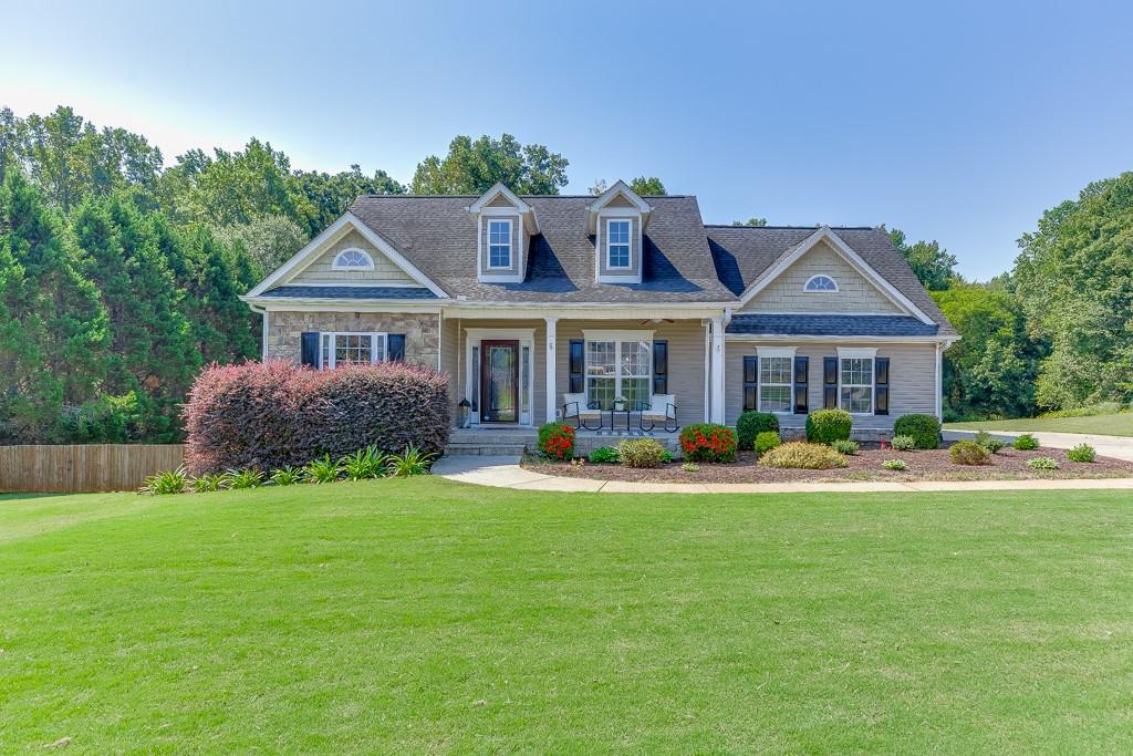 Welcome home to 131 Wood Cove in Jefferson, GA where this beautiful home sits on a large 1.73-acre lot located in the Wood Farm community. Come right in through the charming front porch where you will be greeted in the nice Foyer. The bright Primary Bedroom with vaulted ceilings is conveniently on the main level. Enter the stunning updated Primary En-suite through the sliding barndoor to see gorgeous, tiled shower with glass doors, ship lapped accent wall, garden tub, beautiful cabinetry, countertops, and details galore. Across the home you will find two Secondary Bedrooms, a full Bathroom, and a Laundry Room with a window. In the heart of the home, you will enjoy the tiled Kitchen, Breakfast Room, and Family Room all open that makes it perfect for entertaining. Through the Kitchen you will find the beautiful Dining Room for the best place to share a special meal. Upstairs is a Bonus Room great for a playroom, office or guest bedroom. In the partially finished Basement, you will have even more space with another large Family Room with a fireplace, another Bonus Room, and a Full Bathroom. This basement has so much storage space, as well as a workshop that is set up for a woodworking vacuum. Enjoy time outside on the large deck looking out in this huge yard that is just right for outdoor gatherings and wrapping up your evening around the big firepit area. Come tour this home and dream of making memories of your own at 131 Wood Cove!