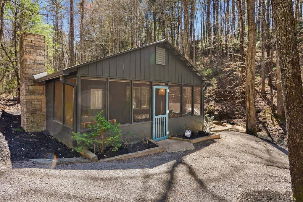 Escape to Blackbird Cottage-an inviting studio tucked in the woods, boarded by a peaceful creek and surrounding forestry land. This fully furnished getaway is a proven short-term rental, blending funky rustic charm with modern comforts. Inside, the open-concept layout features a king-size bed, full kitchen, cozy gas fireplace, and thoughtfully built-in bunk beds that maximize space without sacrificing privacy. The spa-like bathroom includes a floor-to-ceiling tile shower and a tankless water heater so you never have to cut a shower short. Step outside and unwind on the screened in porch an ideal spot for morning coffee or quiet reading. Out back enjoy a dip in the hot tub, or gather around the creekside fire pit for weenie roasting and s'more indulgence. A BBQ grill and outdoor seating make it easy to entertain or simply take in the quiet surroundings. Just a short drive to the shores of Lake Blue Ridge and the Toccoa River, this property offers the perfect mix of seclusion and adventure. Whether you're looking for a weekend retreat or a turnkey rental investment, Blackbird Cottage delivers.