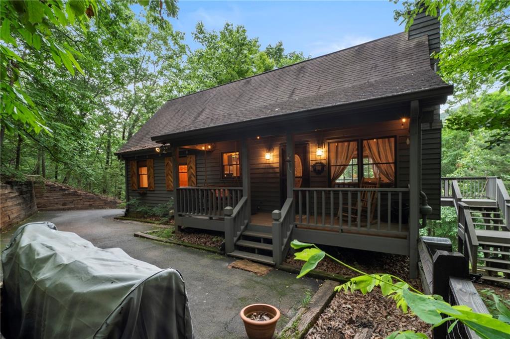 This charming 3 BR - 2 BA cabin has high volume cathedral T&G wood ceiling with exposed beams, hardwood flooring throughout the main level and seasonal mountain views. Wood kitchen cabinets, stone fireplace in the great room, and wood beams in the master b/r which is located on the main level. Expansive wood deck on back and rocking chair front porch on the main level, plus an oversize screen porch on the terrace level. This cabin is located in a very private setting with a year-round running stream located just off to the side of the front porch where you can sit and enjoy endless relaxation and tranquility 24/7. This cottage home can be sold fully furnished and makes for an excellent value with good vacation rental potential. Come see for yourself!