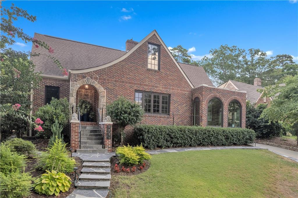 Classic Tudor architecture meets modern refinement in this exceptional Morningside residence, perfectly positioned on one of the neighborhood's most coveted streets. A stone path leads to an elegant stone archway and covered veranda, setting a stately tone before stepping inside. The interior impresses immediately with a grand living room with intricate fireplace detailing nods to the home's historic charm. The dining room connects effortlessly to a light filled sunroom and designer kitchen that will satisfy the most discerning chef-featuring a massive island with waterfall edge, quartzite countertops and professional grade appliances. The living space is extended to a sprawling rear deck-ideal for hosting with style-and a large open family room that anchors the home's main level. Two spacious bedrooms and two full baths round out this floor with both luxury and practicality. Upstairs the primary suite is a private escape with a custom walk-in closet, a deep soaking tub and luxurious shower. An additional bedroom, full bath, and a beautifully appointed office with french doors offer flexibility and function with elegant finishes throughout. This is refined intown living-rich in detail, uncompromising in quality.