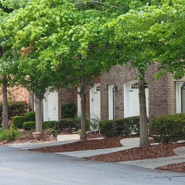 Nestled just off Riverstone Parkway near I-575, this beautifully maintained all-brick townhome offers both convenience and comfort. The main level features a spacious living room with a cozy fireplace, a well-appointed kitchen, a convenient half bath, and direct access to the attached garage. Upstairs, you'll find an oversized master suite complete with a walk-in closet and a private deck—perfect for morning coffee or evening relaxation. Two additional bedrooms share a full bathroom, and the laundry room is thoughtfully located on the upper level for added ease. Appliances including the refrigerator, dishwasher, oven, and dryer are all included. The HOA handles exterior maintenance and lawn care, allowing for a low-maintenance lifestyle. Enjoy the community’s scenic setting near the Etowah River, with access to walking trails, parks, and a charming gazebo. Just minutes from downtown Canton, you'll be close to restaurants, shopping, a theater, and Northside Hospital Cherokee.