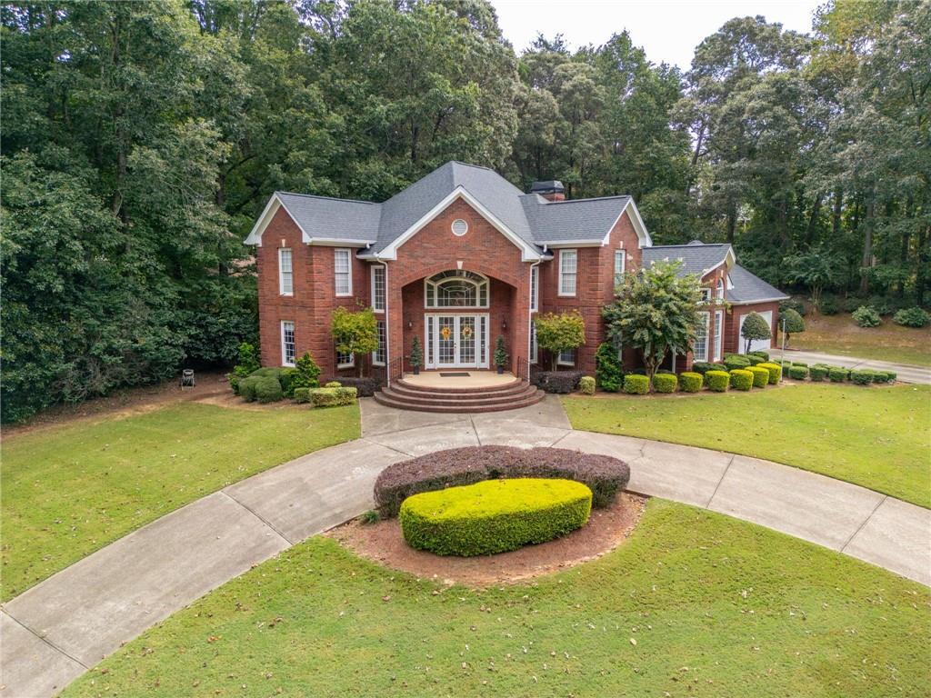 Located in the prestigious Royal Lakes Golf and Country Club in Flowery Branch, GA—just minutes from I-985—this elegant 4-bedroom, 2.5-bathroom home offers exceptional comfort and luxury in a vibrant, amenity-rich neighborhood.
A grand two-story foyer with a striking double staircase welcomes you into a bright, open layout. The home features a private office, a formal dining room, and a soaring living room with expansive windows that fill the space with natural light and offer views of the backyard oasis.
The kitchen is perfect for both everyday living and entertaining, with a center island, breakfast nook, and breakfast bar. The main-level primary suite includes dual vanities, a soaking tub, a glass-framed shower, and a spacious walk-in closet.
Upstairs, three generously sized secondary bedrooms and a full bathroom provide ample space for family or guests.
Outdoors, enjoy a private retreat with a sparkling in-ground pool and hot tub combo, surrounded by rock tile and a patio for lounging or entertaining. The home sits on a beautifully landscaped corner lot with a curved driveway, adjacent to Sloan Mill Rd.
As part of the Royal Lakes community, residents enjoy access to a championship 18-hole golf course, junior Olympic swimming pool with waterslide, clubhouse dining, lighted tennis courts, basketball courts, and over 19 acres of neighborhood lakes—offering scenic views and a resort-style lifestyle right at home.
Discounted rate options and no lender fee future refinancing may be available for qualified buyers of this home.