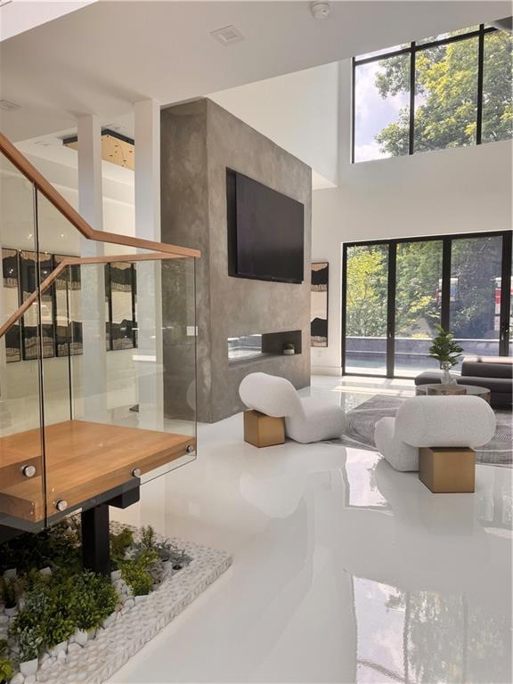 Experience modern elegance at its finest in this architectural masterpiece, ideally located in East Cobb. This stunning residence showcases floor-to-ceiling windows, soaring ceilings, and an open-concept design that perfectly blends natural light with sleek, sophisticated finishes.
Step inside to discover a thoughtfully curated interior featuring a designer kitchen and dining space with a statement chandelier, a floating LED-lit staircase framed by glass railings, and a custom concrete fireplace wall anchoring the spacious living room. Every detail reflects intentional craftsmanship, from the polished high-gloss floors to the contemporary lighting and upscale textures throughout.
The luxurious bedrooms offer serene retreats, complemented by bold accent walls, designer lighting, and outdoor access, while the private home office delivers the perfect balance of productivity and style. Outside, your personal oasis awaits with a sleek modern pool, lush greenery, and a tranquil backdrop designed for entertaining or unwinding.
Perfectly positioned near top-rated schools, The Battery, Truist Park, Chattahoochee River trails, upscale shopping, and dining, this home offers the best of East Cobb living.This rare opportunity to lease a designer modern masterpiece won’t last long. Schedule your private tour today! available for production rental-contact for rates and details