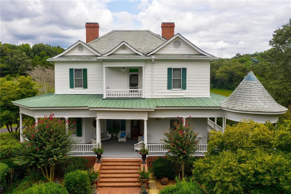 Any day at the farm is truly an experience on this 68 acre estate. Start your morning with breakfast in the gazebo overlooking the lush green acreage. Listen to the babbling fish pond & overlook the stocked fish pond w/dock, or if you prefer, take a walk down to the stables & grab your horse & enjoy trails surrounding the property. Lunch could be served at the 1800 rustic log cabin, a stones throw from the main house or near the Alcovy rivers edge.This property is known for plenty of wildlife especially large Bucks roaming the property. The Circa 1880 Colonial Victorian main home was purchased in Monticello & was moved & was preserved on the property. The setting with mature magnolias and fruit trees is magnificent. The home boasts 12 foot high ceilings on main, heart of pine flooring, & oversized bedrooms. Roof is slate w/attached gazebo. Home features 9 FP, ornate parlor stove, and unique antique lighting that all come with a story. Owners have all the history of the home. Property has a three bedroom caretaker's ranch, 2 car garage/equipment shed, large oak barn & 1800's rustic log cabin guesthouse. Plenty of room for the whole family & plenty of space to build other residences on the property.