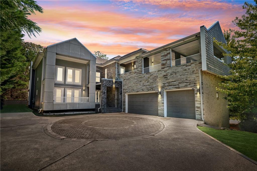 Welcome to this striking contemporary residence, where thoughtful design meets gracious living in a blend that feels both luxurious and warm. As you step into the dramatic two-story great room, walls of windows draw in natural light, while crisp architectural lines and soaring ceilings create a gallery-like strength tempered by comfort. A flexible layout features two kitchens and a welcoming guest bedroom on the main level, making entertaining and daily living both comfortable and convenient. With ample garage space for three vehicles, this home is as practical as it is beautiful. Step outside from the dining room onto the covered back patio, leading to the beautifully landscaped backyard and a charming gazebo—ideal for quiet afternoons or starlit gatherings. Downstairs, the fully finished basement includes an in-law suite with its own full kitchen, an exclusive exterior entry, and an interior entry—perfect for extended family, guests, or a private workspace. The basement also boasts a media room equipped with WiFi projector and a huge 16’ wide projection screen, creating a premium home theater experience. Upstairs, the expansive master suite is a phenomenal retreat: custom shelving, an impressive custom-built walk-in closet, and a spa-level bath that showcases a frameless glass shower and a soaking tub. You’ll love stepping out onto the massive covered deck off the master suite, where morning light and evening breezes mingle above your private, lushly landscaped yard. Every room is designed with lifestyle in mind, from quiet nooks with light streaming in to open entertaining zones that flow naturally. The home was crafted to deliver both grandeur and coziness. Just outside your door, you’ll discover a host of nearby recreation and local treasures. The nearby Sewell Mill Creek Loop in East Cobb Park provides an easy walking trail under tree canopies, perfect for daily strolls or birding. The historic Strand Theatre in Marietta offers live performances, classic films, and cultural events in a beautifully restored atmosphere. This home offers an exceptional balance: bold, contemporary architecture with inviting spaces; indoor sophistication with seamless outdoor living; and a prime location that places you minutes from nature, culture, and the charm of Marietta.