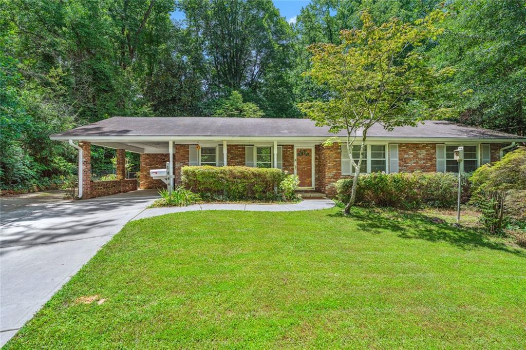 Welcome to this charming 1960s four-sided brick ranch, offering single-story living with timeless elegance. Hardwood floors grace the entire home, even under the carpet in the bedrooms and hall. The spacious eat-in kitchen with a breakfast nook opens onto a patio through sliding glass doors, perfect for entertaining. Enjoy three large bedrooms with ample closet space and one and a half baths. The oversized living room offers versatile space that can also be a Living Room/ Dining Room Combo. The private fenced backyard features beautiful landscaping with established trees and a large shed for storage. A one-car carport and the long driveway add convenience and plenty of parking to this delightful home. This home is located around the corner from a City of Tucker park boasting walking trails, a playground, dog parks, park benches, and a gazebo. With easy highway access and close proximity to shopping, restaurants, entertainment, plus Emory Hospital and the CDC, this home keeps you connected to all the best Metro Atlanta has to offer.