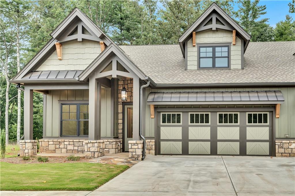 **$2,500 Custom Interior Paint Allowance & $2,200 Refrigerator Allowance** Imagine yourself in a charming Dogwood Cottage nestled in Active Adult Community of The Village on Blackwell Creek, a community with multiple stunning homes completed and under construction. With the convenience of future on-site amenities, as well as the option to buy-in to nearby Big Canoe community amenities, this community has all of the comfort of a small community, with all of the benefits of a larger HOA! Each townhome cottage offers the ease of main-floor living, with 1,655 square feet featuring a serene master suite, a cozy secondary bedroom with its own bathroom, and soaring 11-foot ceilings that create an open, airy ambiance. Wide 8-foot doors, vaulted ceilings, and gorgeous manufactured hardwoods throughout the main level, enhances the sense of space and flow. The gourmet kitchen is a cook’s dream, complete with gleaming stone countertops, abundant cabinetry and extra pantry space, a gas range, and a spacious island with an integrated sink—perfect for preparing meals while entertaining guests. Step outside onto the generous rear covered screened porch that overlooks peaceful green space, ideal for relaxing in the fresh air. Upstairs includes an additional bedroom and full bath, ideal for guests, caregivers, or even a home office, with low maintenance luxury LVP flooring throughout. With a two-car garage, convenient main-floor laundry room, wired for a generator, and thoughtful layout ensure comfort and practicality throughout. The association fee covers insurance, all exterior building maintenance, landscaping, trash pickup, internet, and TV service—and nearby walking trails and pavilions giving you a carefree lifestyle in a nature-filled sanctuary that feels like a luxurious retreat every single day. Only attached at the garage and with sound-proofing and insulating spray foam throughout- this property lives like a fully detached home! Additional fully completed properties for sale in the community. These properties won't be available for long... schedule your showing today!!