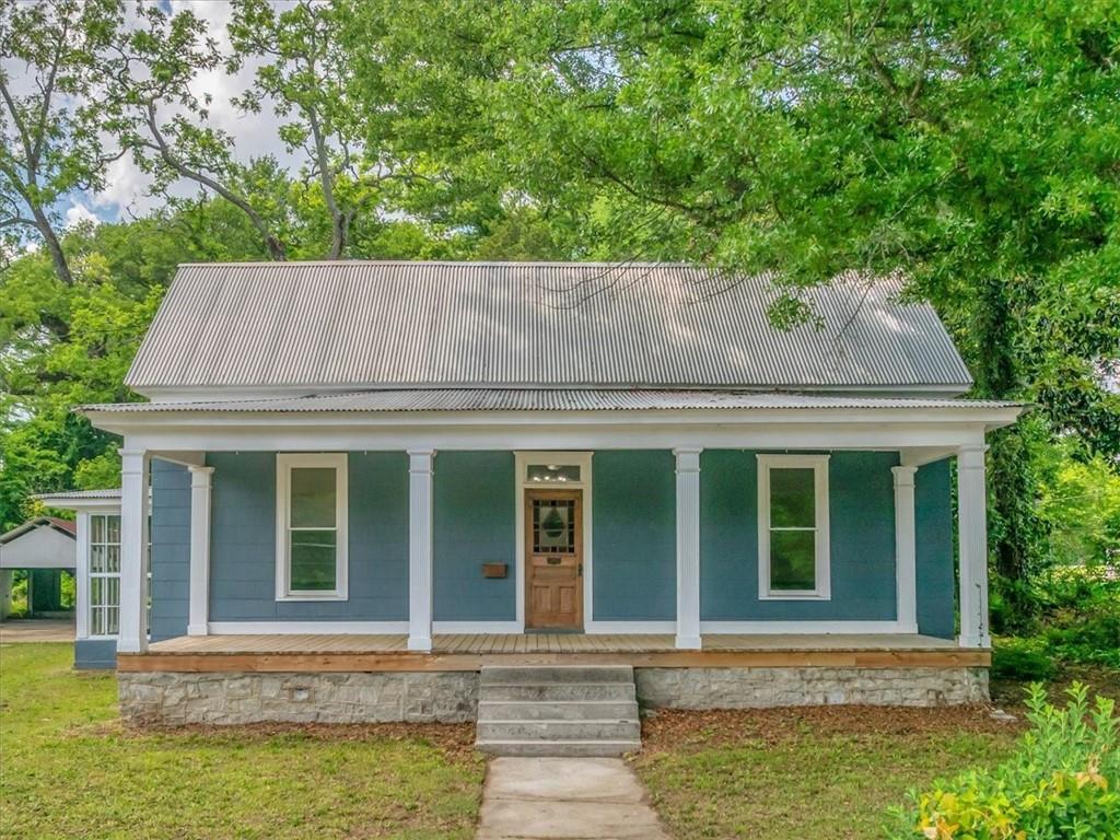 Circa 1880 | 2500+ SqFt of Historic Elegance in Olde Town Conyers Step into a rare blend of timeless Southern charm and modern convenience in the heart of the Olde Town Conyers Historic District! This beautifully preserved 4BD/2BA home spans over 2,500 square feet and overflows with character-from its soaring beadboard ceilings and dentil moldings to original picture railings and a stunning stained glass front door with transom window and vintage mailbox. This home is full of modern updates that offer comfort and peace of mind: New HVAC system & water heater; New stainless steel appliances; New sewer lines; Fresh interior & exterior paint and a long-lasting metal roof. Inside, enjoy hardwood flooring, high ceilings throughout, and a layout built for flexible living. The sunroom-with original tile and separate entry-makes a charming bonus space. The large kitchen has room for an eat-in area, or you can opt for a separate dining room just off the kitchen. The living room welcomes you with an original fireplace, creating a cozy focal point as you enter the home. The detached garage adds even more value, offering ample storage and workshop space-perfect for artists, hobbyists, or anyone needing room to create. A dream for history lovers, creatives, and those who appreciate enduring craftsmanship. Picture yourself porch-sitting on warm evenings, hosting neighbors, or strolling to local restaurants, shops, and festivals-all just steps away in the heart of Olde Town Conyers.