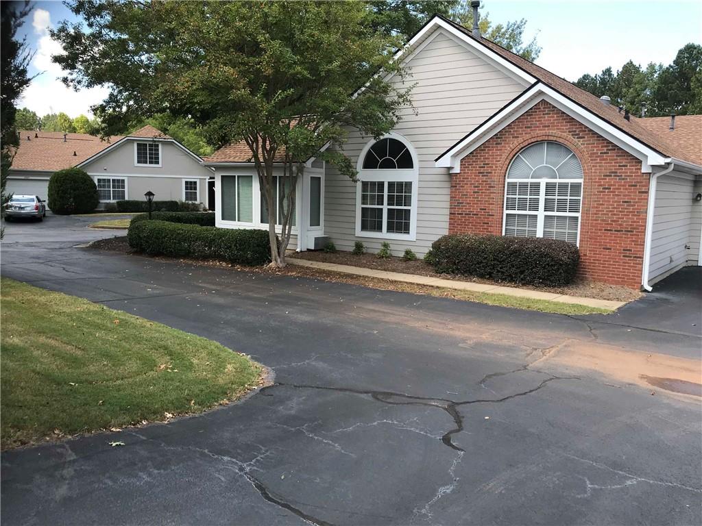 Welcome Home to Comfort and Convenience! This charming ranch-style condominium in The Vineyards, one of Kennesaw's most desirable and active communities, offers the perfect blend of peaceful living and modern convenience. Ideally located with easy access to I-75, top shopping, and dining options, this home offers everything you need for a low-maintenance, hassle-free lifestyle. Say goodbye to lawn care and exterior upkeep—the HOA takes care of all landscaping, so you can spend more time enjoying the amenities. With regular social events, including brunch on the 1st Saturday of each month, you’ll quickly feel at home in this friendly, tight-knit community. Enjoy access to a clubhouse with a fitness center, library, swimming pool, and gazebo, or unwind by the serene ponds with water fountains. Scenic walking paths lined with fragrant flowers provide the perfect backdrop for relaxation and exercise. Step through the front door into a spacious, open-concept layout that’s flooded with natural light, thanks to soaring vaulted ceilings and large windows. The cozy family room with a gas-log fireplace flows effortlessly into a sunroom, making it an ideal space for both everyday living and entertaining. The updated kitchen features sleek white cabinetry, granite countertops, stainless steel appliances, and a tiled floor—perfect for cooking and gathering. The primary suite offers a private retreat with a custom walk-in shower, dual sinks, a large vanity, and a spacious closet. Two additional bedrooms and a full bath with custom tile floors provide flexible options for guests or a home office. The convenient laundry room offers added storage and direct access to the two-car garage, complete with additional attic storage space. With its inviting floor plan, thoughtful updates, and beautiful surroundings, this home offers the perfect setting for those looking for a welcoming community and the ease of condo living. Don’t miss out on the opportunity to make this your next home!