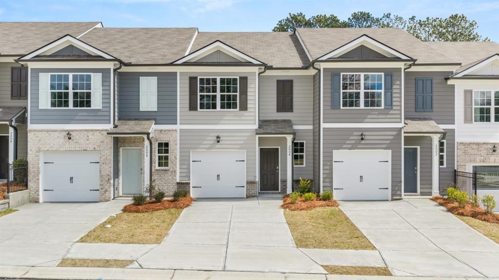 Craftsman house with a shingled roof, concrete driveway, an attached garage, and brick siding