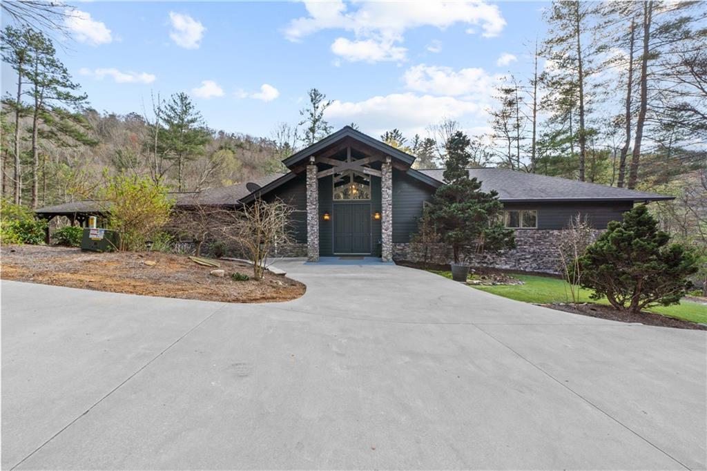 Majestic mountain home on over 25 acres in Ellijay. Come home to this stunning property where you, your family and friends will have acres to roam, hike, relax and play. This home is close in and convenient to all that Ellijay and North Georgia have to offer. Newly renovated with contemporary new paint inside and out, this house is a dream come true and will rival any new construction. The property includes so many features including koi pond with waterfall and a clean mountain stream rolling through. Gated property with paved concrete driveway.
As you enter the welcoming entry with double doors, there are vaulted cedar ceilings with stunning beams. The great room will floor you with a stunning enormous stacked stone fireplace as the main focal point! We are not kidding - this house will WOW you!!! Boasting new and refinished hardwoods throughout with over 2500 square feet on the main level alone, the cooks kitchen with stone countertops, gorgeous cabinets, walk in pantry even includes a dumb waiter to lower level making multi level entertaining easy! Plenty of room for all your dining room ideas and views to the landscape of the peaceful woods and the sounds of your beautiful stream! French doors lead to your deck overlooking a view like no other.
The private primary suite offers its own balcony for morning coffee, a great size bathroom with marble everything and a spacious custom built walk in closet. But there is more. Step into your private sunroom/study with massive deck right next to you. Imagine soundly sleeping with the slider open and the screen door listening to nature and the babbling brook.
Completing the main level are two additional bedrooms with two additional private bathrooms (one an ensuite) and an office with custom built-ins that could easily be a guest bedroom. And if this isn't enough, the lower level is ready for finishing to your needs as a fun entertainment area, bedrooms, or would make a fabulous in-law suite complete with full bath facilities including accessible double sized shower. All of this plus a work room and oversized garage that can accommodate two larger trucks, SUVs, boat and storage galore. There is even a generator system for back up.
The stunning acreage includes lovely evergreen foliage including, mountain laurel everywhere! There is an amazing garden ready for planting any and all vegetables and flowers you could every want. The garden has its own well and watering system!
Property like this does not come around often. Come and see it and be prepared to be amazed.
There is an additional 15 attached acres that border the National Park available for purchase.