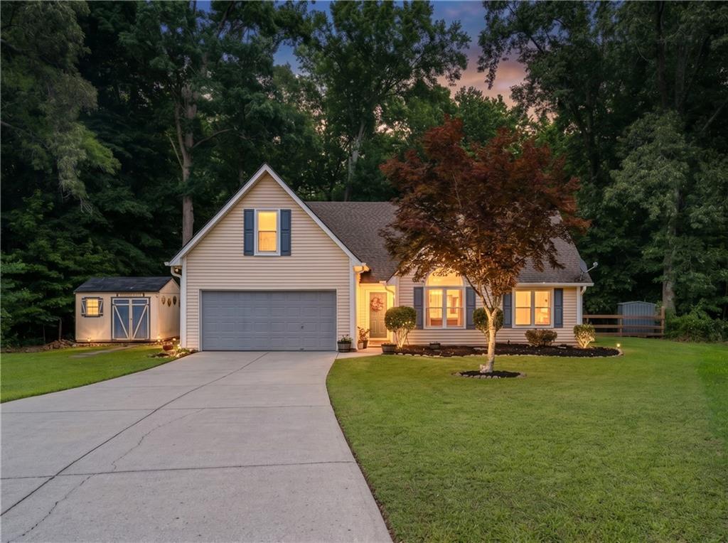 Single-family residence featuring a light-colored siding exterior, an attached garage, and a concrete driveway