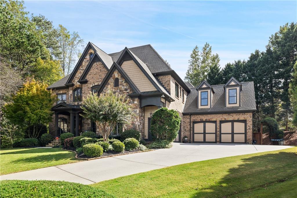 Nestled on a quiet cul-de-sac premium lot, this breathtaking brick and stone residence delivers unrivaled luxury and convenience. With a rare 4 ½-car garage and an exceptional location, the home showcases dramatic 10-foot-plus ceilings and exquisite custom finishes throughout, creating a perfect blend of grandeur and warmth. This exceptional property also features a brand-new roof, adding peace of mind for years to come.
Enter through the stone porch entryway and custom solid wood front door into a dramatic two-story entrance, where you are greeted by elegant hardwood floors that flow seamlessly throughout the main level.
Step into the gourmet kitchen, a chef’s dream featuring stunning countertops, a Sub-Zero built-in refrigerator, a Wolf 6-burner gas cooktop, Wolf double convection ovens, and an elegant marble backsplash. A walk-in pantry with custom shelving provides ample storage, while the adjacent vaulted keeping room with a stone fireplace offers the ideal space for intimate gatherings or cozy nights in. Step onto the expansive covered deck, which overlooks the stunning gunite pool and hot tub—a true entertainer’s paradise.
On the main level, a full guest suite with a private bath ensures comfort and privacy, while the formal living room, complete with custom built-ins, exudes elegance. The dramatic great room is a showstopper, featuring a stunning stone fireplace, 14-foot coffered ceilings, and a wall of windows that frames views of the magnificent backyard.
Upstairs, the master suite is a serene retreat with vaulted ceilings and a brand-new spa-inspired bath. Luxuriate in heated marble floors, quartz countertops, a soaking tub, a spacious shower, and a custom closet system. A connected bonus room/office adds flexibility for work or relaxation. All secondary bedrooms offer the beauty of hardwood floors and generous space.
The daylight terrace level is designed for entertainment, featuring two media rooms—one enclosed and wired for surround sound for an immersive movie experience, and the other open for casual gatherings. A full bar equipped with premium appliances makes hosting effortless. This level also includes a bedroom that can serve as a guest room or office, along with an adjacent full bath featuring a rain shower for added convenience. Other highlights include Nest thermostats, a whole-house Pegasus water filtration system, and a spacious utility room for extra storage.
Outside, the fenced backyard is a private oasis. Enjoy a lighted basketball court with a bounce-back net for lacrosse, a charming treehouse, a putting green, and a fully equipped outdoor kitchen with a custom stone bar and fireplace. The gunite pool and hot tub with a copper poolside fire and water bowl make for the ultimate outdoor retreat.
Living in Creekstone Estates offers more than just a beautiful home. The community includes a full-time tennis pro, multiple tennis courts, pickleball, two swimming pools, a modern clubhouse, a playground, basketball courts, and an activities director who organizes events year-round. Located just minutes from Route 400, The Collection, and Halcyon, this home also offers the convenience of Alpharetta living with the advantage of low Forsyth County taxes.
This exceptional property combines luxury, lifestyle, and location—an opportunity not to be missed!