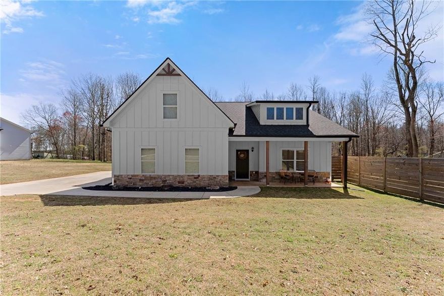 PRICE IMPROVEMENT!!! Custom Ranch-Style Home on 1.29 Acres - No HOA!  Welcome to this beautifully upgraded ranch-style home, nestled in an exclusive 12-home subdivision with no HOA restrictions. Situated on a spacious 1.29-acre lot with a privacy fence encompassing a large portion of the lot, this home offers tranquility, modern elegance, and thoughtful upgrades throughout.  Step inside through the custom front door and you're welcomed by the deep mahogany LVT flooring. The open concept living area features a cozy wood-burning fireplace, perfect for relaxing on those cold days. The kitchen is a chef's dream, boasting Black Pearl granite countertops, stainless single bowl sink, subway tile backsplash, and oil-rubbed bronze fixtures. Your family will enjoy the convenience of being served at the kitchen island or in the adjacent dining area. The bathrooms continue the luxurious feel with rectangular sinks and a fully tiled owners shower with a glass door and extra rain showerhead.  The owner's suite and secondary bedrooms are conveniently located on the main level, while a large fourth bedroom with full bath is situated upstairs, ideal for guests, a teen, or your private home office.  Enjoy outdoor living at its finest with a large covered rear patio, custom built, two-tiered deck with a hot tub, a swing set, and a storage shed. This incredible property is a rare find-offering privacy, space, and top-tier finishes with no HOA restrictions!   Don't miss your chance to own this stunning home! Schedule your private showing today.