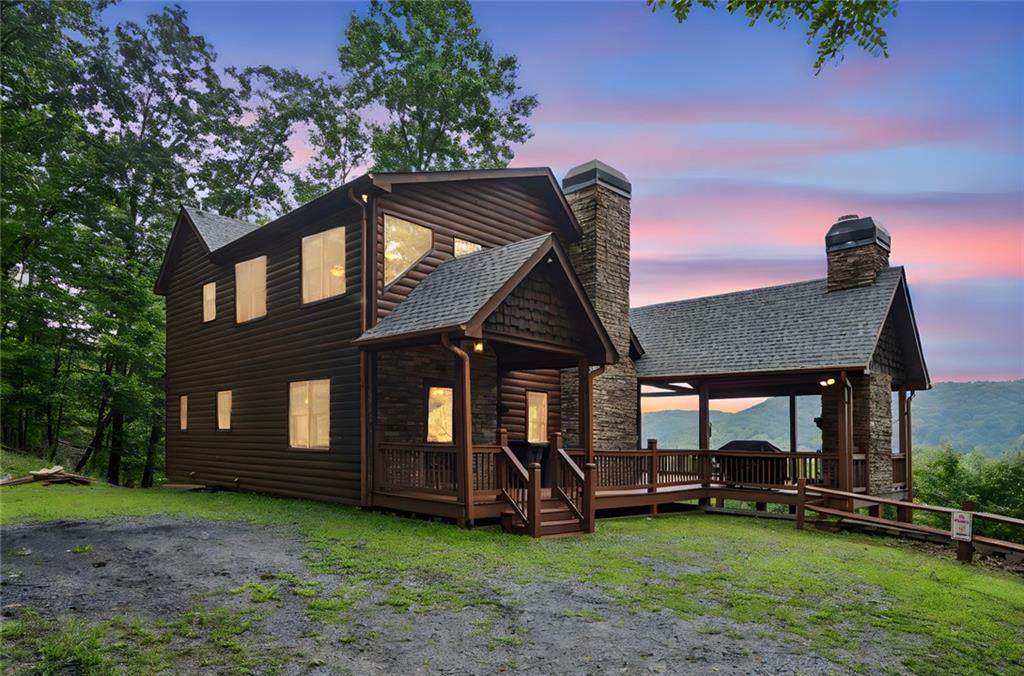 Imagine waking up to the crisp mountain air, with a private balcony just through your French doors, overlooking a serene, wooded landscape. Rental income when you aren’t personally enjoying the mountain is the perfect way to offset your mortgage. This charming cabin-style home in Morganton, GA, offers the perfect blend of rustic elegance and modern comfort, providing the ideal escape from the everyday hustle.
The main level welcomes you with a cozy great room, centered around a beautiful gas log fireplace, perfect for relaxing evenings. The adjacent kitchen, with its warm wood-stained cabinets and sleek granite countertops, offers a comfortable space for preparing meals. The breakfast area, just off the kitchen, is an ideal spot to enjoy your morning coffee or evening dinners. The main level bedroom, featuring French doors that lead to the back porch, provides a peaceful sanctuary. The bathroom on this level boasts a granite tile floor, a tub/shower combo, and a double vanity.
Step out onto your main level porch and gather around the new stone fireplace, creating a perfect outdoor living space for entertaining or unwinding in the mountain air.
Ascend to the upper level to discover a spacious owner’s suite bedroom with French doors opening to a private balcony. The owner’s bath is a spa-like oasis with granite tile, a jetted tub, a separate shower, and a double vanity. A large walk-in closet provides ample storage. A loft on this level offers a versatile space for a home office, reading nook, or creative studio.
The lower level is an entertainer's dream, featuring an open rec room with a stone heart, gas fireplace and granite wet bar. A large bedroom with a walk-in closet and access to the lower back porch offers privacy for guests. Through the hall, find a full bathroom with a single vanity and a tub/shower combo, along with a laundry room, completes this functional level.
This Morganton home is designed for those who seek tranquility and comfort, or those looking for their next investment. With Starlink Wi-Fi already installed, you'll have fast and reliable internet access, even in this secluded mountain setting. Don't miss your chance to own this slice of North Georgia heaven!
