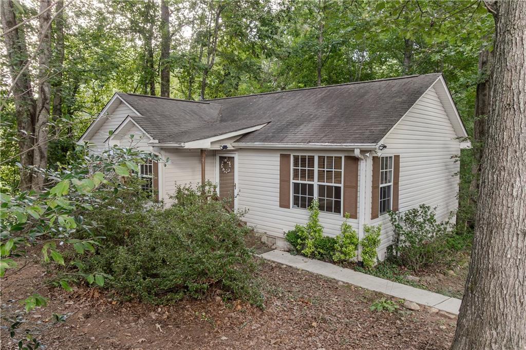 Turn your dream of home ownership into a reality. This cute ranch style home has a beautiful view of mature trees and serene natural lot perfect for entertaining. This 3 bd 2ba home has lots of natural light and hardwood floors. Eat in kitchen which opens to the family room. Kitchen opens up to a large deck overlooking private back yard for entertaining. Large primary bedroom with tub/shower combination.
If you are a dog lover there is a large fenced in area and large/ storage doghouse. Nice level lot to have a garden or just enjoy the natural beauty of the surroundings. This home is perfectly positioned near local wineries, Downtown Dahlonega and the University of North Georgia. Ideal home for first time home buyers or someone looking for one level living. No rental restrictions and would be a great get away for someone wanting a second home or a VRBO. call Patty to see home today.