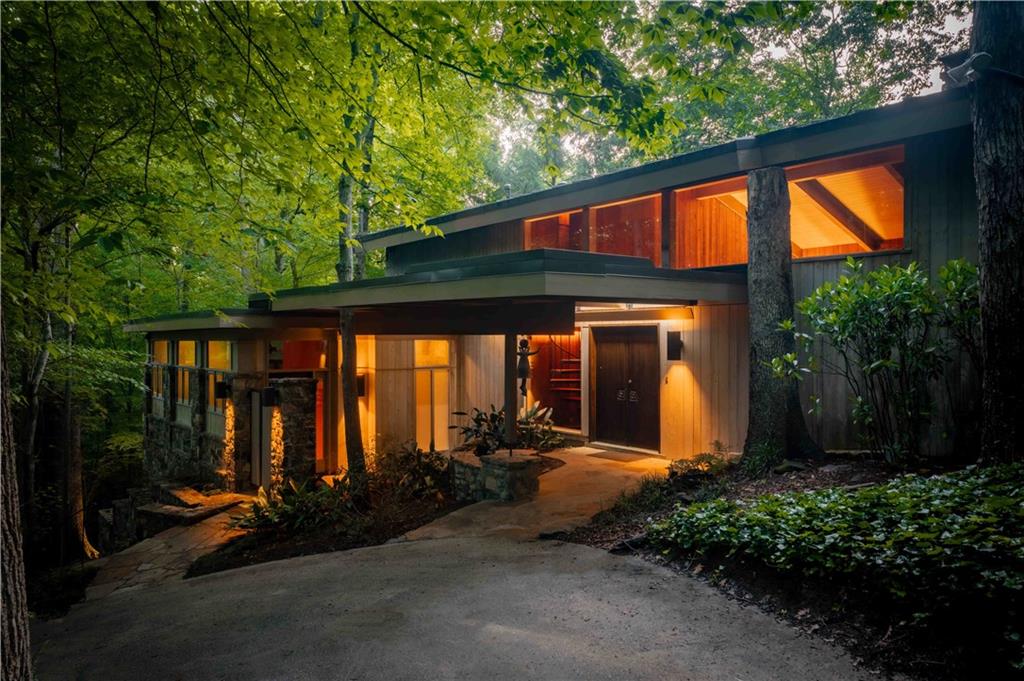 Welcome to THE FALLS. A period correct mid-century modern masterpiece that honors timeless design while embracing progressive innovation & celebrates nature as a lifestyle. Designed by renowned Atlanta architect Herbert Millkey, the home is a showcase of natural materials and meticulous craftsmanship—from hand-selected stone to wormy chestnut paneling milled from a single, historic tree. Every element inside reflects a commitment to organic architecture, with walls of glass that dissolve the boundaries between structure and setting, and private balconies extending from every bedroom overlooking the dramatic, ever-present 120 foot cascading WATERFALL that flows just beneath the edge of the home.
Spanning three unique levels, the home is designed for flexibility and generational living, including an award-winning “age-in-place” addition that functions as a fourth bedroom, private studio, or guest retreat. The interiors flow seamlessly, anchored by a recently updated kitchen connected by sight lines that always lead back to THE FALLS. A spa-like primary suite boasts a Japanese-inspired garden and bath, creating a personal retreat that feels rooted in calm and balance. Four bedrooms. Three baths. Multiple living spaces. Perfect balance.
Throughout the home, there's a constant sense of movement and stillness—of water, wood, and stone working together in quiet harmony. Expansive outdoor living spaces are thoughtfully designed for year-round enjoyment overlooking almost 4 acres of preserved nature and a climax Piedmont Forest that is literally in the heart of the city. The striking & distinctive nature of this home provides a once in a lifetime opportunity to live in the center of nature while also living in the center of everything. There is over a mile of non-contiguous walking trails, bridges, & sitting areas spread across the property. Fed by peavine creek that stretches over 500 feet in length across the property, the waterfall itself spans 100 foot in width, 120 foot in cascading length, & has an island in the middle of it’s two outpourings flooding the home with ever present sounds & visuals of wonder & beauty.
The Falls is not just a home, but a living experience—where architecture doesn’t sit on the land, it becomes part of it…where nature comes first. BRILLIANT!