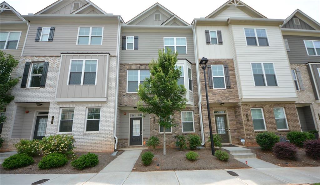 This like-new and move-in-ready home boasts the most extensive floor plan in the community, offering exceptional comfort, space, and style. The popular Hawthorn floor plan features three bedrooms and 3.5 bathrooms, including a spacious Owner's Suite and a Guest Suite on the top floor. An additional bedroom with a full bath is located on the first level, ideal for guests or a private home office. The heart of the home is the stunning kitchen, complete with a massive center island, granite countertops, a tile backsplash, stainless steel appliances, and an open view into the inviting family room. Elegant finishes include gleaming hardwood floors and a beautifully crafted wrought iron rail staircase. The rear covered deck, complete with a ceiling fan, provides an excellent space for both entertaining and relaxation. The refrigerator is included, and the washer and dryer are negotiable. Ideally located just off I-75, it provides easy access to parks, shopping, dining, and top-rated schools, making it an ideal choice for convenient everyday living.