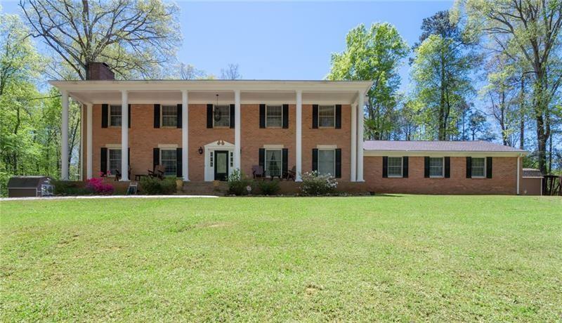 Welcome to this Charming, Mini Mansion, 6 Bedrooms, 4.5 Bathrooms Colonial Home Sitting Royally on a 4.2 Acres Lot in the Heart of Marietta, Georgia. This Home Offers Modern and Vintage Designs with Lots of Upgrades. The Long Asphalt Driveway Lands at the Top of a Newly Installed Flagstone Patio with a Stacked Stone Fireplace for Outside Entertainment. Enter the Royal Doors to a Gorgeous Limestone Tiled Foyer. At the Heart of the Home is the Renovated Gourmet Kitchen with an Island, Separate Eating Area, Granite Counters with a Stunning Backsplash, Custom Cabinets, 5-Burner Cooktop, Stainless Steel Appliances, Double Oven & Convection Oven and Dual Stainless Steel Sink. The Oversized Master Suite Exudes the Luxurious Feeling of Relaxation. Separate Tiled Shower, Double Vanities, Walk-in Closets, and a Cozy Sitting Area. Bedroom & Bathroom on the Main. Upstairs Secondary Bedrooms are Generously Sized and Have Lots of Closet Space. Separate Dining Room with Crown Molding Adds a Touch of Sophistication. Snuggle up in the Living Room in front of the Fireplace. Separate Family Room with Fireplace and Built-Ins. Need More Space? Enjoy Movie Night in a Man Cave/She Shed with Lots of Room for the Entire Family to Enjoy. Floor to Ceiling Windows. Freshly Painted. 4-Sided Brick. 2 Separate Outside Sheds. 3 Car Garage. New Backyard Deck with 2 Ceiling Fans and Lighting. Hardwoods Throughout. Lots of Natural Light. Rocking Chair Porch. NO HOA. Local Shopping At The Avenues, Restaurants, Marietta Square Nearby, Great School District. Too many benefits to List. Come Take A Look.