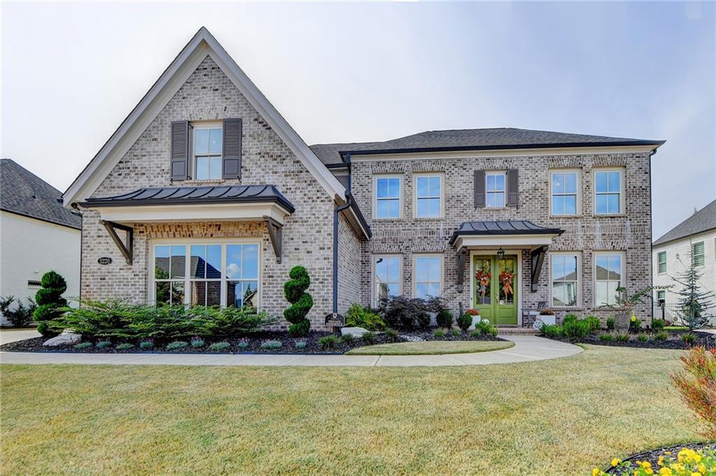 Welcome to the highly desirable Montebello community, where this stunning French-inspired, three-sided brick home awaits. Showcasing the popular Odett Plan, this home features timeless design, luxurious finishes, and thoughtful upgrades throughout. The professionally landscaped front and backyard include an in-ground sprinkler system and architectural up-lighting. Custom shutters and fresh exterior paint give the home a polished look, while an extended driveway and oversized side-entry two-car garage provide plenty of parking. The fully fenced backyard is perfect for entertaining, with an extended covered patio, privacy screens, and lush landscaping. Enter through grand double glass-pane doors into a soaring two-story foyer. The main level is designed for both elegant living and everyday convenience. A formal dining room with a coffered ceiling and a large butler's pantry is perfect for hosting. A private office provides a quiet workspace. The expansive kitchen is a chef's dream, featuring an oversized quartz island, custom cabinetry, a walk-in pantry, and high-end stainless steel appliances, including a six-burner Z-line gas cooktop and double ovens. The kitchen overlooks a family room with a stone fireplace, built-in bookshelves, and custom shiplap trim. Engineered hardwoods flow throughout the main floor, which also includes a convenient fifth bedroom and a full bath. Upstairs, the oversized primary suite is a true sanctuary along with custom walk-in closet. The spa-style bath offers a soaking tub, separate shower, and dual vanities. Three additional generously sized bedrooms and two full baths, along with a large media/bonus room with engineered wood flooring, complete the upper level. Ceiling fans have been installed in every bedroom for added comfort. This professionally decorated home is move-in ready and has been meticulously maintained by its original owner. Montebello offers unmatched amenities, including a resort-style swimming pool, clubhouse, lighted tennis and pickleball courts, and a three-acre lake. With a prime location near top-rated Forsyth schools, shopping, and dining, this property is a must-see!