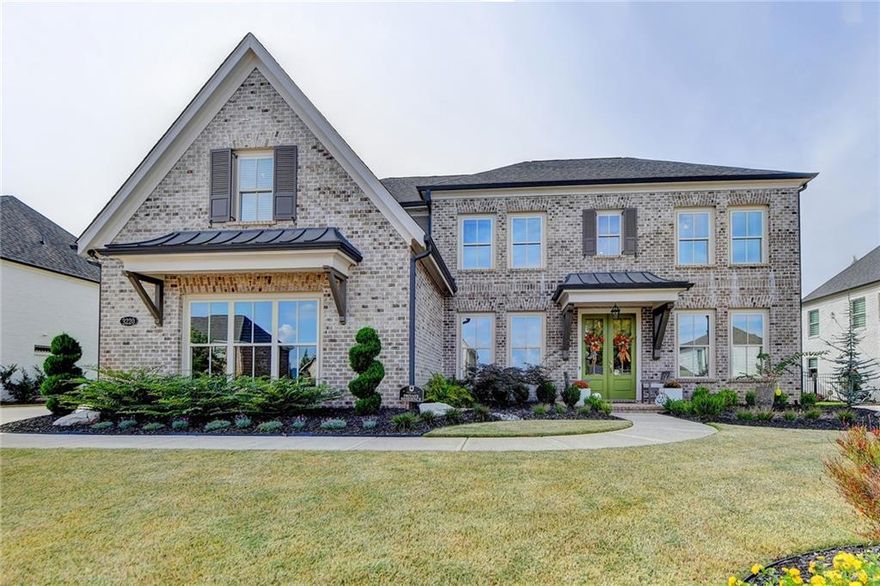 Welcome to the highly desirable Montebello community, where this stunning French-inspired, three-sided brick home awaits. Showcasing the popular Odett Plan, this home features timeless design, luxurious finishes, and thoughtful upgrades throughout. The professionally landscaped front and backyard include an in-ground sprinkler system and architectural up-lighting. Custom shutters and fresh exterior paint give the home a polished look, while an extended driveway and oversized side-entry two-car garage provide plenty of parking. The fully fenced backyard is perfect for entertaining, with an extended covered patio, privacy screens, and lush landscaping. Enter through grand double glass-pane doors into a soaring two-story foyer. The main level is designed for both elegant living and everyday convenience. A formal dining room with a coffered ceiling and a large butler's pantry is perfect for hosting. A private office provides a quiet workspace. The expansive kitchen is a chef's dream, featuring an oversized quartz island, custom cabinetry, a walk-in pantry, and high-end stainless steel appliances, including a six-burner Z-line gas cooktop and double ovens. The kitchen overlooks a family room with a stone fireplace, built-in bookshelves, and custom shiplap trim. Engineered hardwoods flow throughout the main floor, which also includes a convenient fifth bedroom and a full bath. Upstairs, the oversized primary suite is a true sanctuary along with custom walk-in closet. The spa-style bath offers a soaking tub, separate shower, and dual vanities. Three additional generously sized bedrooms and two full baths, along with a large media/bonus room with engineered wood flooring, complete the upper level. Ceiling fans have been installed in every bedroom for added comfort. This professionally decorated home is move-in ready and has been meticulously maintained by its original owner. Montebello offers unmatched amenities, including a resort-style swimming pool, clubhouse, lighted tennis and pickleball courts, and a three-acre lake. With a prime location near top-rated Forsyth schools, shopping, and dining, this property is a must-see!