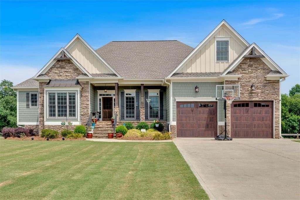 Welcome to an exquisite riverfront home in the highly coveted Shaw Woods neighborhood, where luxury meets unparalleled natural beauty. This stunning residence, perfectly situated overlooking the Etowah River, offers meticulously crafted details and breathtaking views, ensuring a life of comfort and serenity. Step inside the grand foyer and be immediately captivated by the home's impressive features. Soaring ceilings, exposed wood beams, and gleaming hardwood floors create an immediate sense of elegance and spaciousness. The open-concept design seamlessly connects the main living areas, inviting you to explore further. Off the foyer, a sophisticated separate dining room boasts a graceful tray ceiling and elegant wainscoting, setting the stage for memorable gatherings. As you move through the home, you'll discover a thoughtfully designed floor plan that prioritizes effortless living. The expansive family room flows seamlessly into the gourmet chef's dream kitchen, creating the ultimate hub for entertaining. The family room features striking wood beams and a cozy stone fireplace, while the kitchen is a masterpiece of design, offering custom cabinetry, upgraded appliances, granite countertops, a charming stone backsplash, a massive kitchen island, and a convenient walk-in pantry. These impressive spaces provide direct access to an enormous screened-in back porch, complete with ceiling fans and another inviting fireplace—perfect for enjoying the river breeze year-round. Beyond the screened porch, a small, uncovered deck offers the ideal spot for your grill. The master suite is a private sanctuary, strategically separated from the other bedrooms for ultimate tranquility. This luxurious retreat boasts vaulted ceilings, beautiful wood beams, a captivating river view, and direct access to the screened porch. The generously sized master bath is a spa-like haven, featuring a freestanding tub, a large walk-in shower with multiple shower heads, and double vanities. Clever pocket doors throughout the master suite ensure seamless flow and accessibility. You'll also appreciate the oversized master closet, complete with a custom closet system, which conveniently connects to the laundry room for unparalleled ease. Adjacent to the master suite, a versatile room awaits, ready to be transformed into an office, playroom, guest room, or whatever your lifestyle demands. A full bath nearby adds to the convenience. The opposite wing of the home features a thoughtfully designed Jack-and-Jill bedroom and bath, with another Jack-and-Jill bedroom and bath located upstairs, providing ample space and privacy for family and guests. This exceptional home sits atop a full unfinished basement, offering incredible potential for customization. The basement includes a dedicated storage area, a convenient garage/boat door, and walk-out access to a sprawling, level, and fenced-in yard – perfect for pets and play. Outside the basement, a long, mostly covered patio provides another fantastic space for outdoor enjoyment, complete with an additional fireplace and a dedicated dog kennel area. Every detail in this home has been meticulously considered, leaving absolutely nothing to be desired. It's more than just a house; it's a lifestyle waiting to be embraced. Ready to experience the dream? Book your showing today!