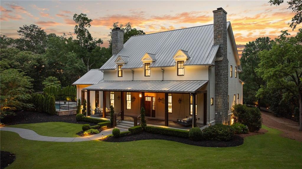 Welcome to your own private retreat in the heart of Milton. Set on 2.5 beautifully wooded acres behind a gated entry, this custom-built modern farmhouse by Steve Powell Homes combines timeless craftsmanship with the laid-back luxury of resort-style living. With a heated saltwater pool and spa, outdoor fireplace, and a backdrop of century-old oaks, this home offers the kind of privacy and setting that’s getting harder to find. From the moment you step onto the front porch, framed by cedar beams, gas lanterns and tongue-and-groove ceilings, you’ll feel the attention to detail that sets this home apart. Inside, 12-foot ceilings, reclaimed Pennsylvania barn wood floors, and natural light at every turn create a bright, welcoming feel. The fireside family room opens into a chef’s kitchen with quartzite countertops, a high-end appliance package, large center island, and walk-in pantry. Accordion-style doors lead to a vaulted, wood-lined lanai—an all-seasons space with a fireplace that flows effortlessly into the pool and patio area. The main-level primary suite is a true escape, featuring a spa-like bath with heated floors, a soaking tub, dual showerheads, and a custom walk-in closet with a packing island. Just off the closet, the laundry room is a workhorse—with space for two washers and two dryers, tons of cabinetry, a work island, built-in desk, and drop zone. Whether you’re managing a busy household or prepping for travel, this space makes life easier. Upstairs, you’ll find four generously sized en suite bedrooms, each with custom walk-in closets, plus a versatile bonus room and a cozy reading nook that’s perfect for quiet moments or homework hangouts. The finished terrace level adds even more to love—a full home theater, a flex space that works well as a gym or guest suite with its own full bath, and a fourth-car garage that easily doubles as a workshop or extra storage. Need more room to spread out? Above the main garage, an additional finished space offers endless potential—whether it’s an in-law suite, a game room, or your go-to spot for entertaining. From the Control4 smart home system and full-house generator to the winding drive, professional landscaping, and extra parking pads, no detail has been overlooked. Zoned for top-ranked Cambridge High and just minutes to Downtown Alpharetta, Avalon, and GA-400, this property offers the rare mix of privacy, convenience, and laid-back luxury that’s getting harder to find.