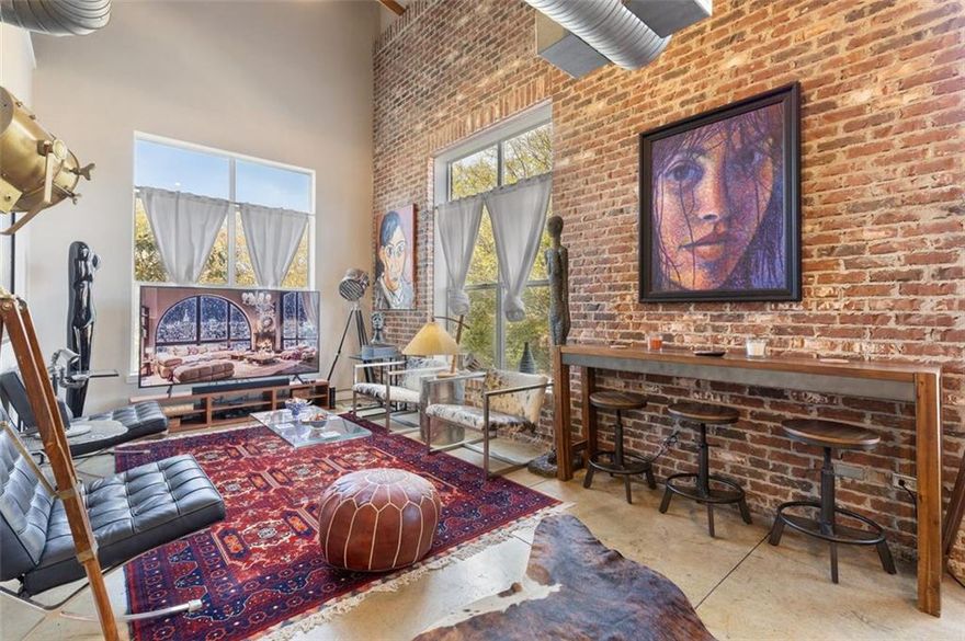 Discover vibrant luxury in this furnished industrial loft near Marietta Square. This 2-bedroom, 2.5-bathroom space combines nostalgic charm with modern urban style, ideal for those who appreciate the finer things. Crafted by a classic film enthusiast, the loft features an open concept living area with industrial chic furnishings, exposed brick walls, high ceilings, and large windows that fill the space with natural light. The gourmet kitchen boasts stainless steel appliances and sleek countertops, perfect for culinary adventures. Bedrooms offer peaceful retreats with vintage movie memorabilia. The main bedroom includes a spacious lounge area and ample storage. Located near Marietta Square, enjoy easy access to dining, shopping, and entertainment. This loft's cinematic charm and prime location make it a must-see. Schedule a private showing today!