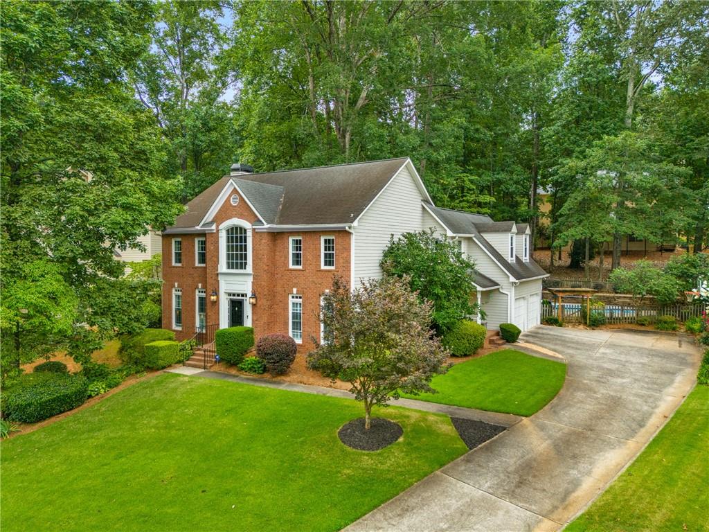 Welcome to this beautifully updated home featuring an inviting two-story foyer with a second-story balcony that adds architectural charm. Upon entry, you're greeted by elegant formal living and dining rooms, both enhanced with plantation shutters, window transoms, and convenient access to a newly updated powder room. Gleaming hardwood floors run throughout the home, complemented by oak stair treads and custom iron balusters leading to the upper level. The open-concept kitchen boasts quartz-finished granite countertops, freshly painted cabinetry and island with shiplap detail, updated pendant lighting, and stainless steel appliances. It flows seamlessly into the spacious family room, which includes a cozy fireplace, new ceiling fan, and access to the rear screened porch. A secondary staircase off the kitchen offers added convenience. Upstairs, the master suite features double doors and an updated en-suite bath with dual vanities, quartz-finished granite countertops, new mirrors, and modern lighting. Four additional generously sized bedrooms share a renovated hall bath with dual vanities and fresh paint. The screened porch has been upgraded with new teakwood flooring, tongue-and-groove ceiling, ceiling fan, and TV, making it the ultimate four-season retreat. Step outside to your backyard oasis complete with a stone patio, private pool, paved walking trails, and a firepit—perfect for relaxing or entertaining. Recent pool updates include a new pump and saltwater converter. Additional improvements include a new irrigation system, rear yard drange, and a professionally sealed crawlspace with dehumidifier. Located in desirable Garrison Ridge with swim/tennis amenities and an active HOA. All of this, just minutes from top-rated Cobb County schools and shopping.