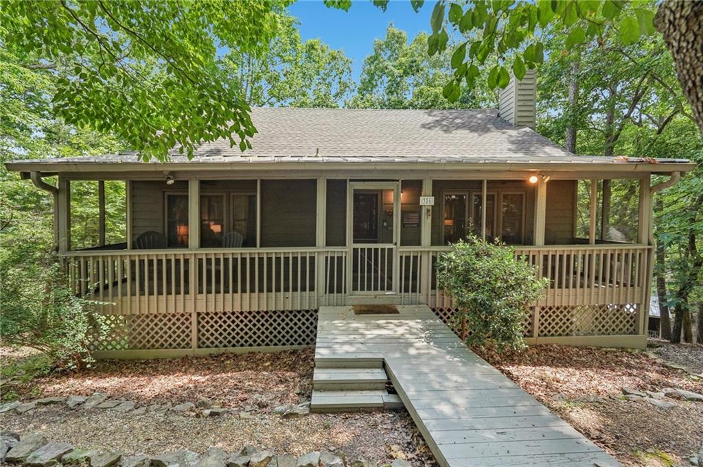 Renovated Plummer Cabin Steps from Lake Petit! Turnkey & Rental-Ready
This beautifully updated 3-bedroom, 2-bath Plummer-style cabin in Big Canoe offers the ideal mountain getaway, just a short stroll to Lake Petit and close to all the community's premier amenities.
The spacious main-level primary suite, vaulted ceilings with exposed beams, wide plank pine floors, and a striking
stacked stone fireplace create a warm, rustic atmosphere. Enjoy two expansive screened porches, a sunroom for year- round comfort, and a large back deck perfect for entertaining or relaxing in the fresh mountain air.
Upstairs, a versatile loft makes a great game room or additional lounge space, while the lower level features two
generous bedrooms and a full bath, ideal for guests or family. You'll also appreciate the covered storage area for your canoe or lake gear.
With a new HVAC system, excellent rental potential, and most furnishings included, this move-in-ready home checks
all the boxes for full-time living, weekend escapes, or income-producing property