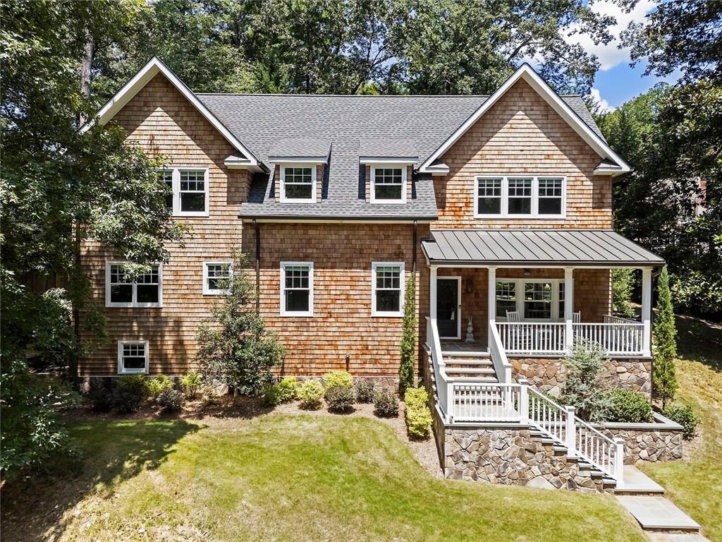 In the heart of Chastain Park, this exquisite Hamptons-inspired renovated home embraces original Earl McMillen-designed charm. Nestled on a quiet tree lined cul-de-sac street, this sophisticated home tucks into a private acre. A charming bluestone front porch leads into a main level living room, with beamed ceilings, oak paneling, and hardwood floors. The kitchen features marble counters, Wolf range, original brick floors and custom steel windows in the breakfast nook. This seamlessly flows into the spacious living room and dining area, as well as the den, all ideal for entertaining and everyday living. Delightful living areas with tons of natural light, sweeping views of nature, and lots of details that add character. The main level also has original primary suite and en-suite bath, and additional bedroom and full bath in hall. The expanded second story addition features new primary suite with en-suite bathroom, double vanities with marble counters, and oversized closet with built ins. Additionally, two en-suite bedrooms and a bonus room drenched in sunlight. Lower level daylight flexible living area, ½ bath, and laundry room. Professionally landscaped and fully fenced, gated front entry, large walk-out patio off kitchen, whole-house generator, Rain Bird irrigation system, and detached 2-car garage with storage and EV charger capacity. Located in the sought after Jackson Elementary school district and just minutes to schools, the PATH, amphitheater, horse park, NYO ballfields, tennis, golf, pool and playground. Easy access to Sandy Springs, Buckhead, and major highways.