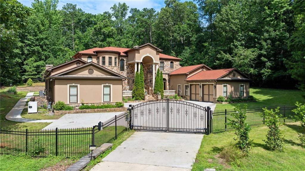 Luminari Manor is a Luxurious Gated Private Estate at the footsteps of Kennesaw Mountain. This stately and impressive home with its stately columns, sets a grand tone as your guests approach. A dramatic two-story entrance, with sweeping spiral staircase, presents an atmosphere of elegance and sophistication. The main level reveals an expansive living room, bathed in natural light from a wall of windows scattering light across the hardwood floors. Enjoy a cozy fireplace and an adjacent bar area, while entertaining or unwinding. High Ceilings throughout create an atmosphere of grandeur. Nearby, a custom wood panel office awaits just steps from the main-level Primary Suite. Retreat to the luxurious primary suite with a sanctuary of comforting relaxation with its spa-like bathroom, and an oversized custom walk-in closet. At the heart of the home, the chef’s kitchen is equipped with high-end appliances from brands Miele and Wolf, ample custom cabinetry, breakfast nook, a well designed pantry and an extensive granite island providing the perfect gathering spot as well as ample workspace. Nearby is a lovely formal dining area with wall of windows. The kitchen expands to a great room providing casual living space with a stone fireplace and a wraparound view of the backyard, creating a seamless indoor-outdoor connection. Step outside into a very private backyard oasis that defines relaxation and luxury. The saltwater, heated pool is a true highlight, with night lighting to enhance evening ambiance. Beautiful landscaping surrounds the pool area, creating a private retreat that feels like a personal resort. Inside and nearby is a powder room with easy access to backyard and pool area. The main level also includes an ensuite guest bedroom, ensuring convenience and privacy for visitors and a laundry room. The upper level, accessed from the impressive spiral staircase, is thoughtfully designed with a split floor plan separated by a bridge overlooking the living room and entry with two ensuite bedrooms on one side and two with a shared bathroom on the other. The fully finished basement is a world of its own, perfect as an in-law suite with its private entrance. It features a large living area, well-appointed kitchenette with a quartz-topped island, a gym area, a serene spa room, and two additional ensuite bedrooms. This space is crafted for independent living, offering both style and practicality. For the car enthusiast, this home offers tall door four-car garage parking split for symmetry, provides ample space for vehicles and storage. Residents can also enjoy immediate access to scenic trails, perfect for hiking, running, or walking their dogs. The location offers easy proximity to Marietta Square, where fine dining, seasonal events, and concerts await. For golf enthusiasts, Marietta Country Club is just five minutes away. Mount Paran school is convenient and nearby. ***SELLERS WILL ENTERTAIN ALL OFFERS***