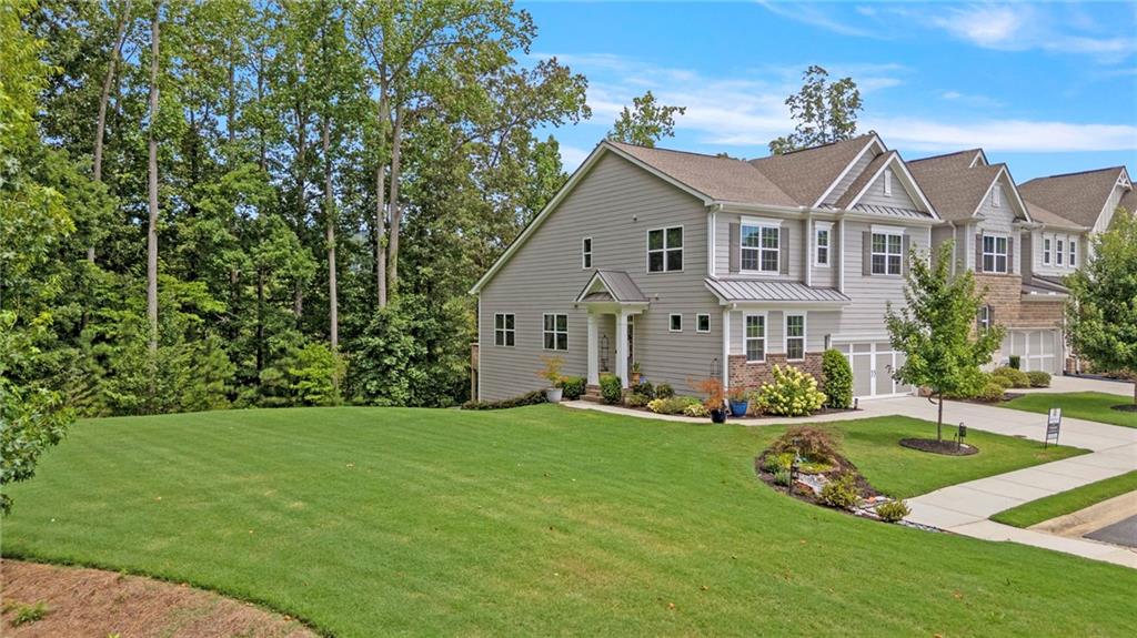 This stunning, one-of-a-kind townhome offers over 3,500 sqft and the ultimate blend of luxury, space, and convenience, featuring a FULL FINISHED BASEMENT, over $100,000 in premium upgrades, and sitting on one of the largest and most private lots in the community. Backing up to the protected Cheatham Creek, enjoy peaceful wooded views and a spacious side yard rarely found in townhome living. The AMENITY RICH neighborhood offers multiple pools (Olympic-style and resort-style), multiple tennis and pickleball courts, a fitness center, clubhouse, playground, community garden, and year-round neighborhood events. There’s even an option to request your own garden plot, providing the chance to grow and maintain fresh produce close to home! Inside, a bright and airy foyer that flows effortlessly into the formal dining room and open-concept main living area. The kitchen is complete with a large pedestal island, breakfast bar, granite countertops, stainless steel appliances, tile backsplash, and pantry. The adjoining family room features a cozy fireplace and access to the upper deck for outdoor relaxation. MAIN LEVEL PRIMARY SUITE offers an elevated feel with tall ceilings, double vanity, and an oversized walk-in tile shower. Upstairs, a flexible loft landing connects two generously sized secondary bedrooms, and an additional full bath. Even a bonus room with an attached storage closet, ideal for a playroom or home office. The FINISHED BASEMENT is the true showpiece of this home, designed for entertaining in style. A sleek wet bar is the centerpiece, highlighted by a coffered ceiling, pendant lighting, stone backsplash, lighted glass display cabinets, and beverage coolers. Nearby, barn doors lead to a private bedroom, and an additional room offers versatility as a gym, media room, workspace, or potential fifth bedroom. The gorgeous full basement bathroom features a fully tiled walk-in shower, creating a luxurious guest experience. Step outside to a covered patio, perfect for hosting gatherings or relaxing in privacy as an extension of the basement and spacious yard. This home is also the only one in the community with its floor plan, making it a rare gem. Enjoy a professionally landscaped exterior, two-car garage, and incredible curb appeal. Lawn maintenance and trash pickup are included for low-maintenance living. Located near top-rated schools, shopping, dining, entertainment, healthcare, and major highways, this home truly offers more than just a place to live, it’s a lifestyle. Don’t miss your opportunity to own one of the most unique and upgraded homes in the neighborhood.