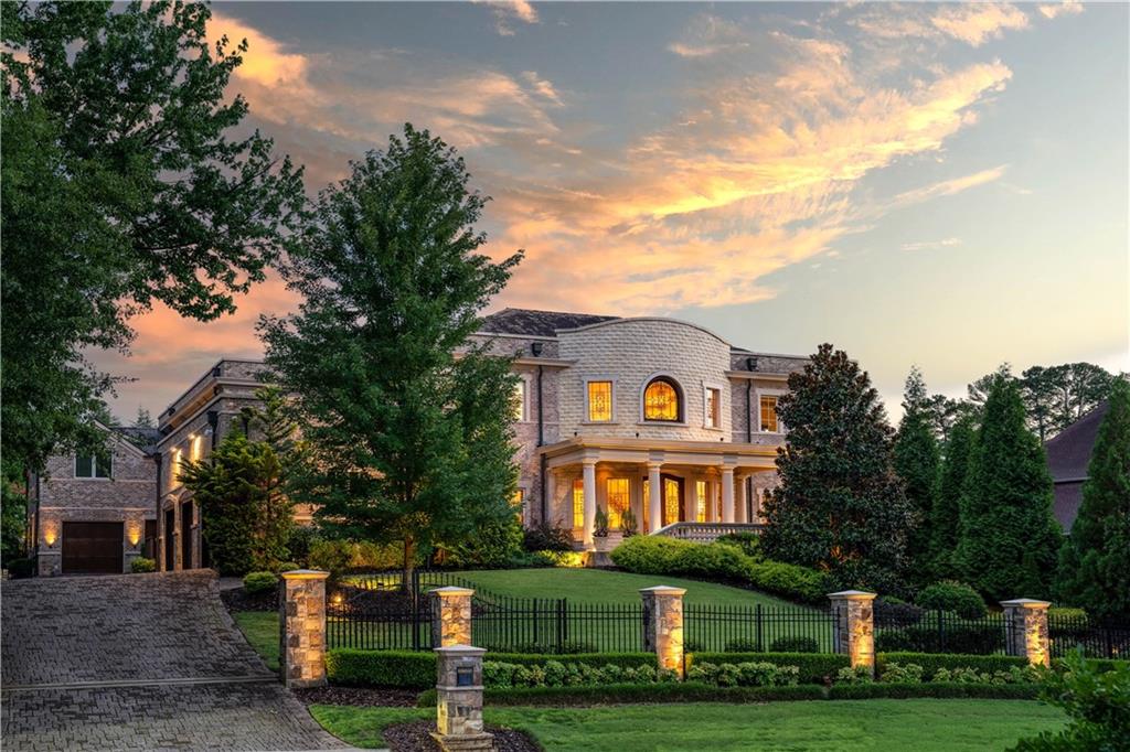 Nestled in a quiet cul-de-sac in Atlanta Country Club and adjacent to a 20-acre McFarlane nature park, this custom estate home was designed for top-of-the-line living. Built in 2009 and designed by Harrison Design, this construction was a 3-year labor of love that spared no expense. With materials sourced and imported from all over the world, this home offers a masterfully curated space that can be appreciated on every level, and down to every last detail. At over 14,000 square feet, this property features 7 bedrooms, 9 full bathrooms and 5 half bathrooms, as well as a 4-car garage and elevator access to all three levels of the home. The inviting foyer and expansive formal rooms feature 24-foot ceilings that provide a spacious layout perfect for entertaining, while still maintaining a cozy atmosphere. The main level owner’s suite boasts a barrel vault ceiling, enormous walk-in closet, and a built-in spa complete with a hot tub, steam room and sauna leading to the pool area. The three upper bedrooms each feature ensuite baths, and also include a private living quarters with a full kitchen, laundry room, and bedroom suite. The upper level has an In-Law/Au-Pair suite, with a private bathroom, separate entrance, and direct single car garage access. The kitchen combines gorgeous, modern design with state-of-the-art appliances to create a space that is equally inviting and practical. With a fully equipped gym, cozy home theater, and secondary family rec room with a projector and pool table, amenities abound for families of all sizes. At just under an acre, the property’s meticulously manicured grounds display a gorgeous street presence while also providing privacy for residents. The stunning, walk-out backyard is perfectly suited if you’re looking to relax and unwind, as well as entertain. The saltwater pool with a Pebble Tec finish, LED lighting, and remote-controlled waterfall features creates a gorgeous atmosphere, and the perfect complement to the outdoor dining area and Pool House. Once you see it for yourself, it’s no surprise this house’s construction was a 3-year undertaking. With unwavering attention to detail, this home ensures luxurious comfort and unparalleled quality that every member of the family will appreciate.