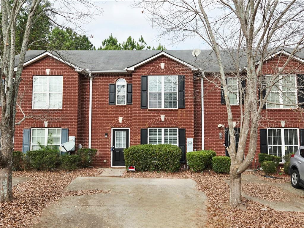 Colonial inspired home with brick siding and roof with shingles
