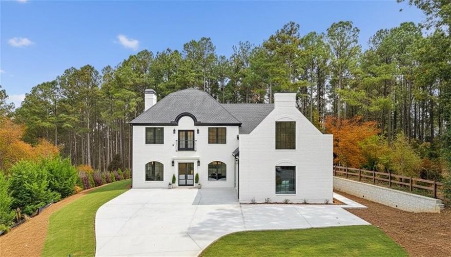 Stunning new construction modern luxury awaits at 606 Talmadge Ln in Governors Preserve. This four-sided painted brick residence features 10'+ ceilings and a dramatic living room highlighted by a floor-to-ceiling quartzite stone fireplace and 3-panel multi-slide glass doors that open seamlessly to the private backyard. The chef's kitchen is meticulously designed with waterfall marble counters, solid surface marble backsplash, a walk-in pantry, along with a breakfast nook, large dining room, and a butler's pantry with quartzite wet bar that make it perfect for family time and entertaining. This flexible multigenerational layout boasts two primary suites with spa like bathrooms-one on each level-including a superb upstairs suite complete with its own private exterior entrance from the garage. The second floor also features a Jack-and-Jill layout with shared access to a charming Romeo and Juliet balcony. Additional functional spaces include a main-level office, an upstairs bonus room, and a versatile room above the garage ideal for a 6th bedroom, media room, or private retreat. All bathrooms showcase marble countertops, custom marble/tile, and high-end fixtures. The property is completed by an oversized garage with epoxy floors and EV charging, and a level backyard perfectly suitable for a future pool. Located in a top-rated school district and minutes to downtown Canton with easy access to Roswell, Alpharetta, and Cumming. This is a rare blend of craftsmanship, comfort, and contemporary design-your next chapter of luxury begins here!